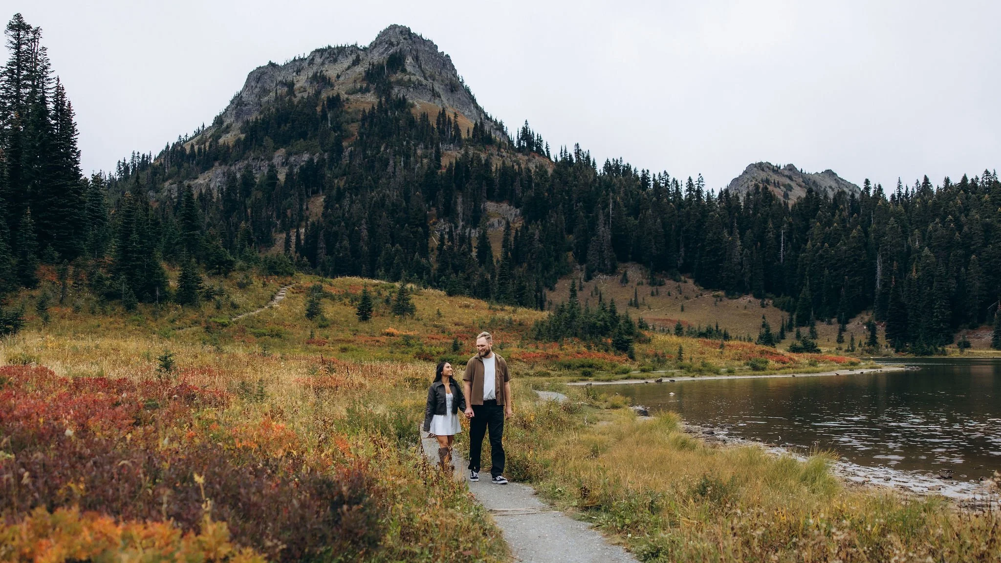 Couple walking along Naches Peak Loop trail during fall, engagement session near Mount Rainier with autumn colors and alpine scenery