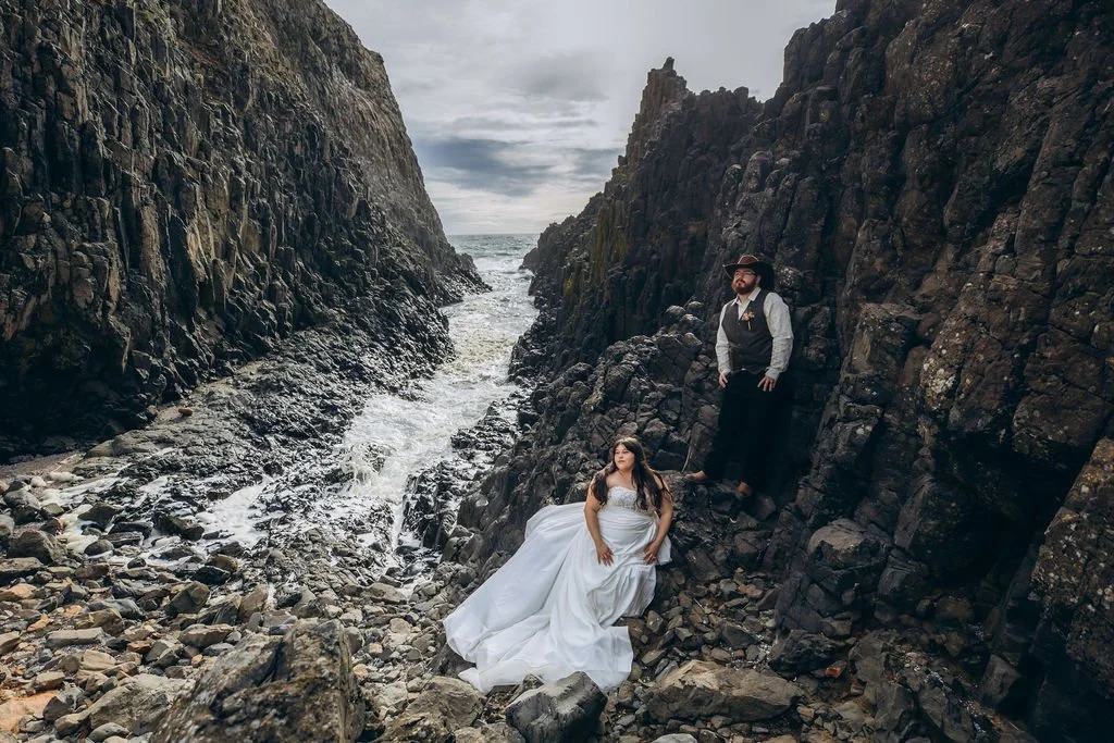 Couple posing among dramatic rock formations during an elopement at a secret Oregon Coast location that feels like Iceland