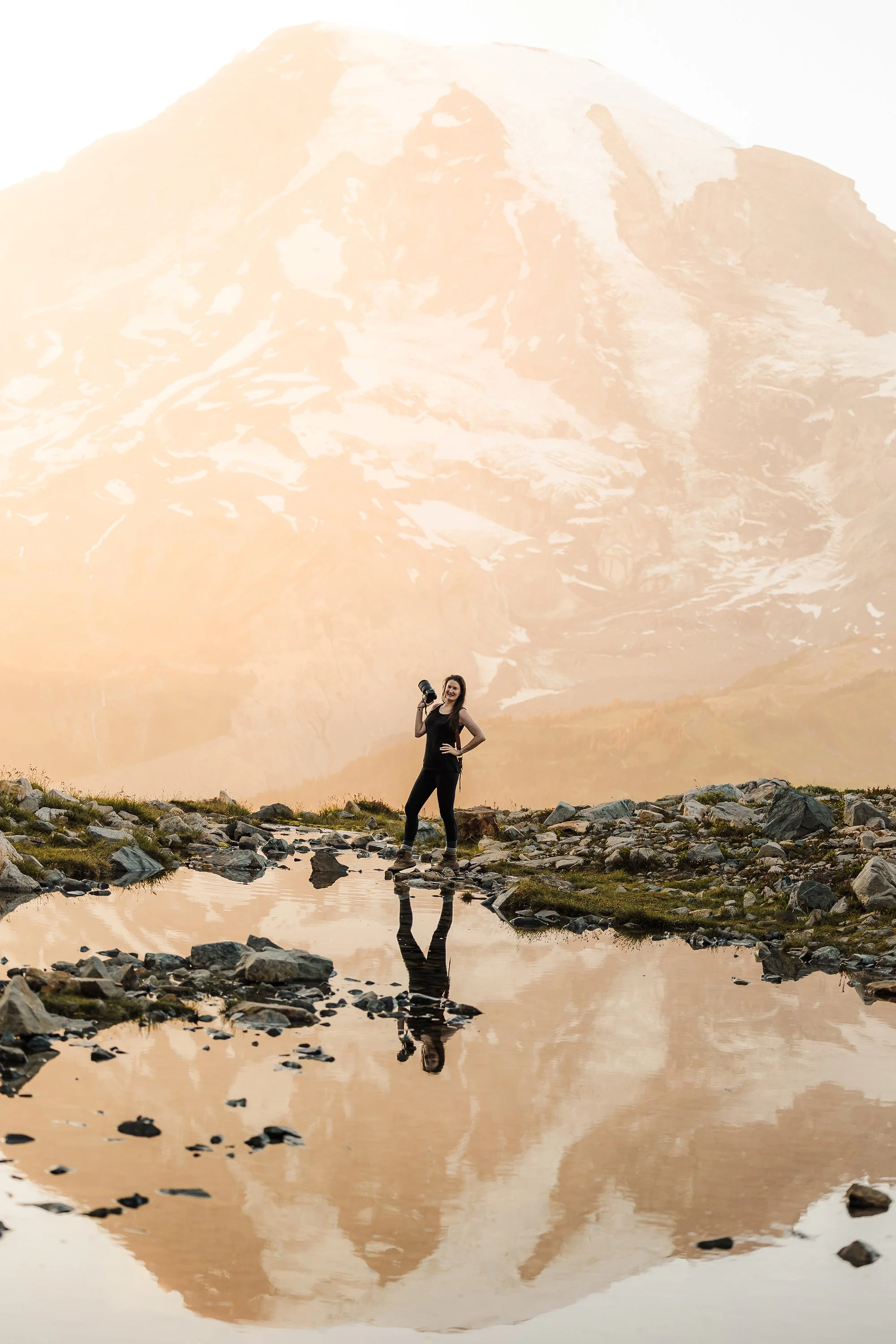 Valerie Lisuk, Washington elopement photographer, standing with her camera at Mount Rainier in the Pacific Northwest