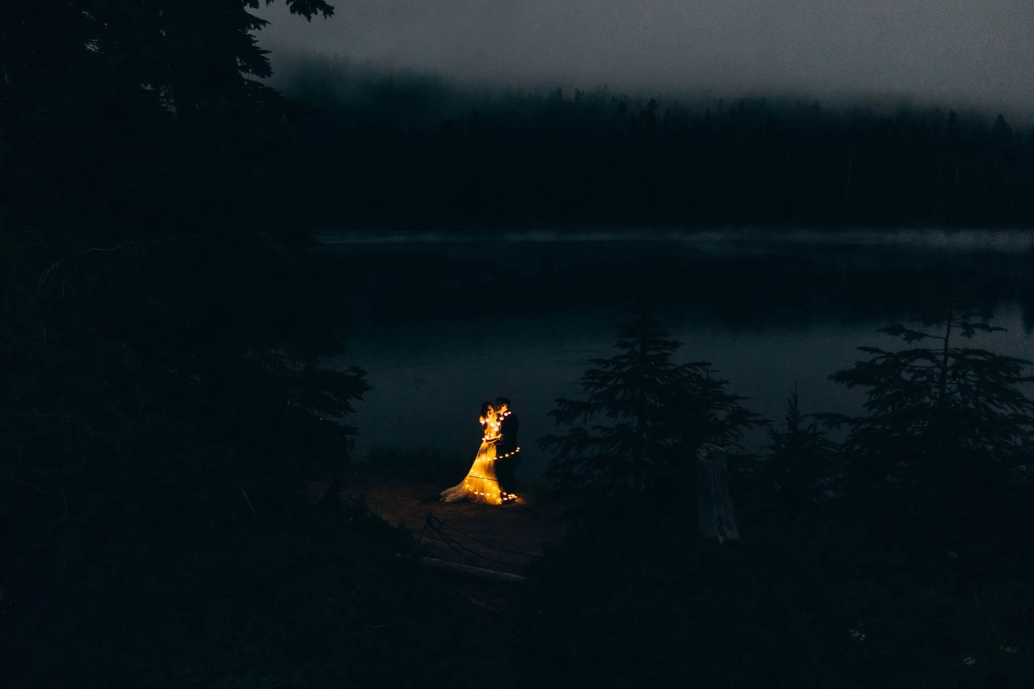 Couple eloping with lanterns at Reflection Lake in the Paradise area of Mount Rainier National Park during blue hour with mountain reflections