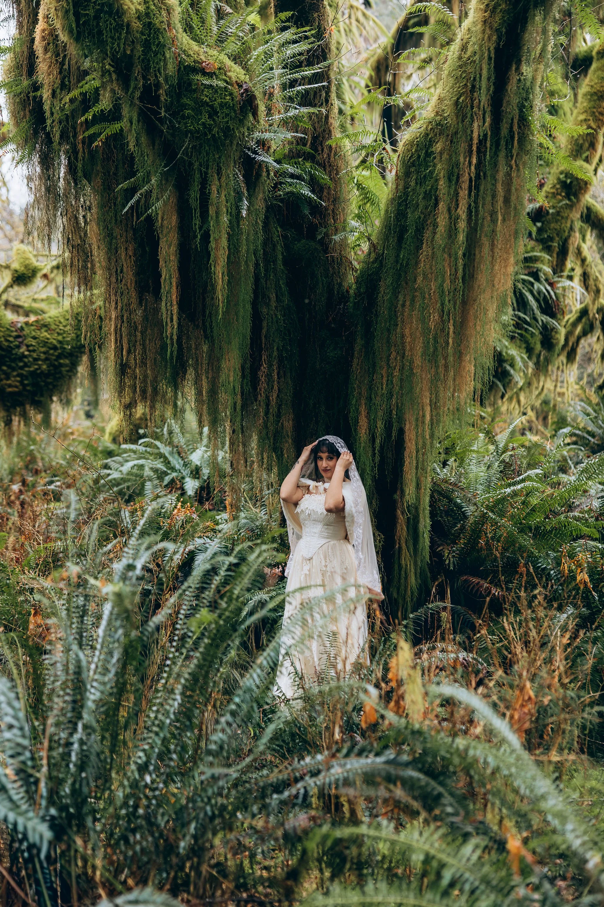 Bride wearing a flowing elopement dress in a lush Pacific Northwest rainforest, showing how a lightweight wedding gown complements an outdoor adventure elopement