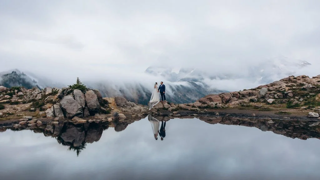 Artist Point elopement at Mt. Baker, featuring a couple standing above a reflective alpine pool in foggy mountain conditions