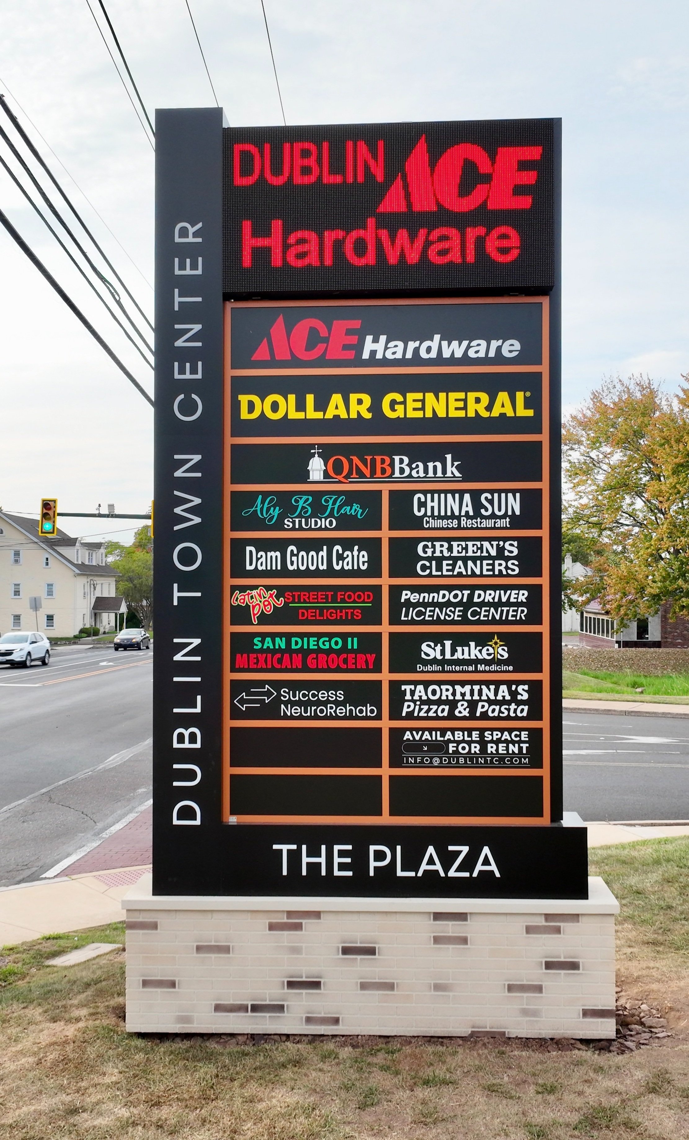 Sign for Dublin Town Center featuring business names such as ACE Hardware, Dollar General, QNB Bank, China Sun, Dam Good Cafe, and others.