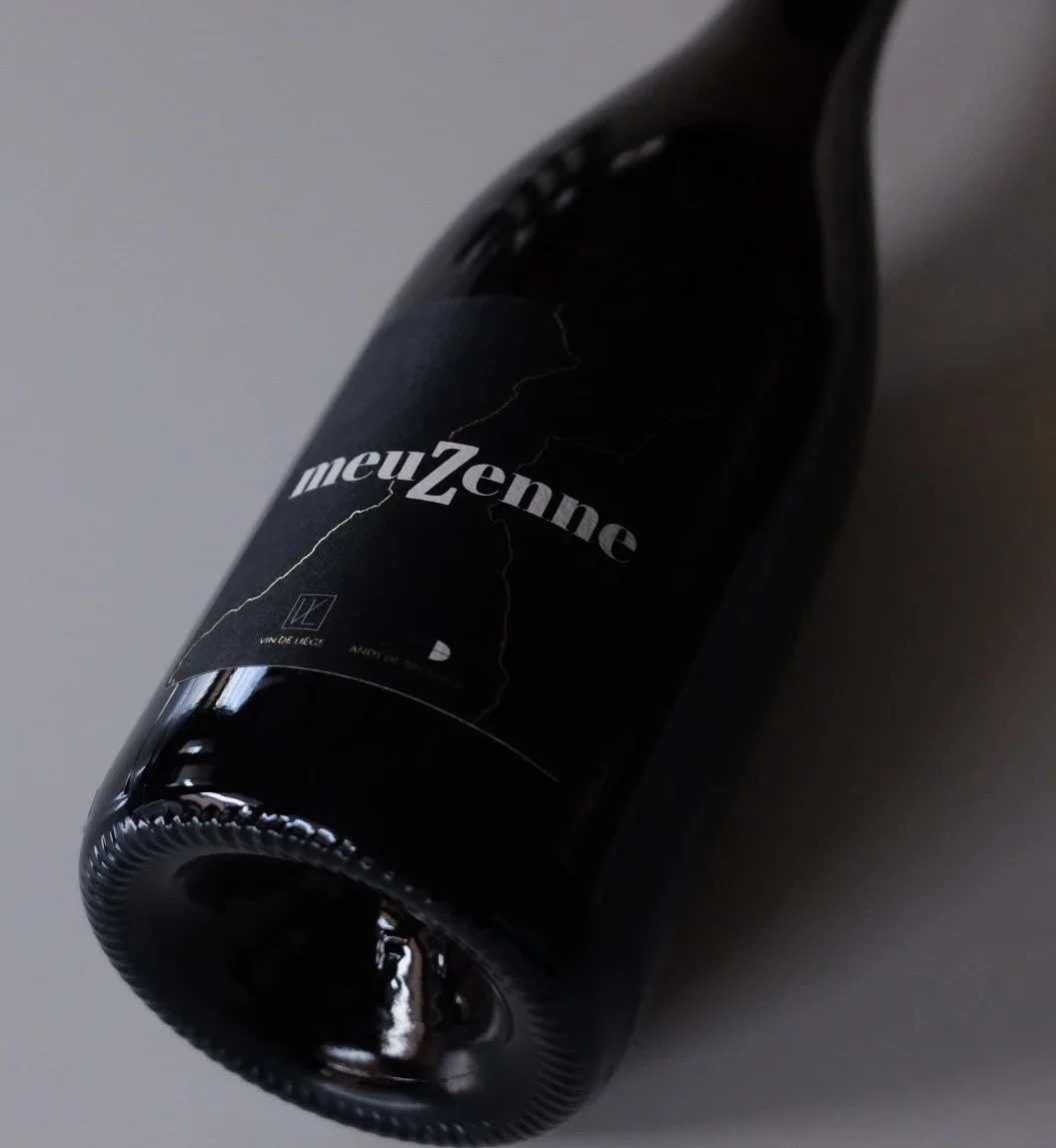 Bouteille de vin rouge avec une étiquette noire portant le nom 'meuZenne'