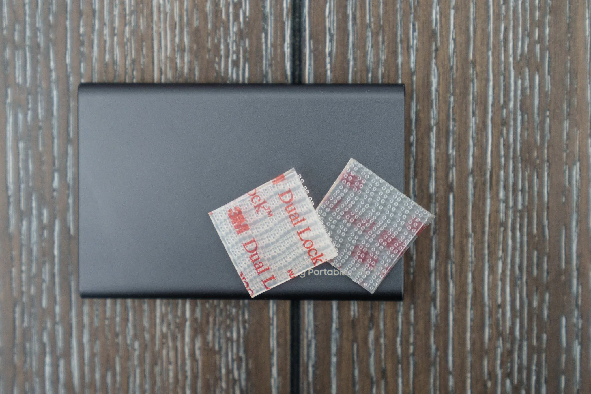 Squares of 3M Dual Lock and an external hard drive