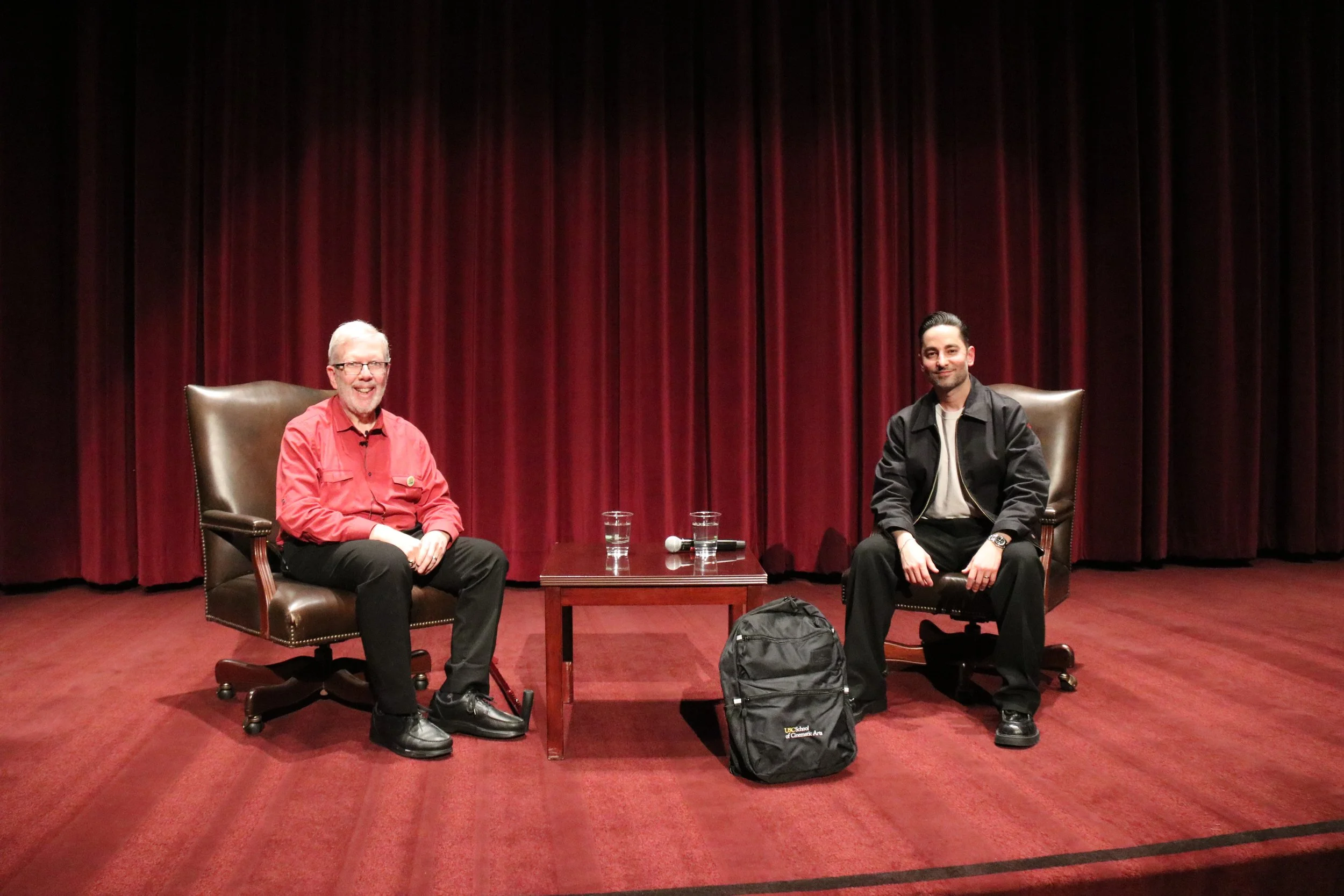 Sev Ohanian (right), SCA alum and producer of "Sinners," joins Leonard Maltin (left) on stage at Norris Theatre for a post-screening Film Symposium discussion on the filmmaking process.