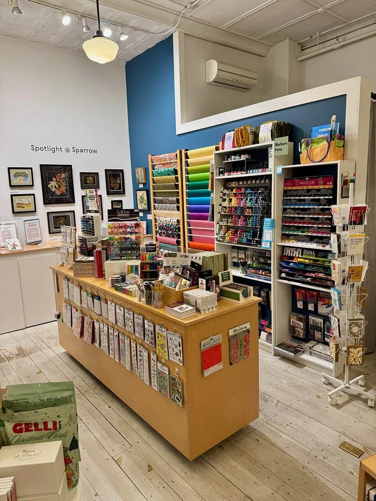 colorful art supplies merchandised in a store against a blue wall