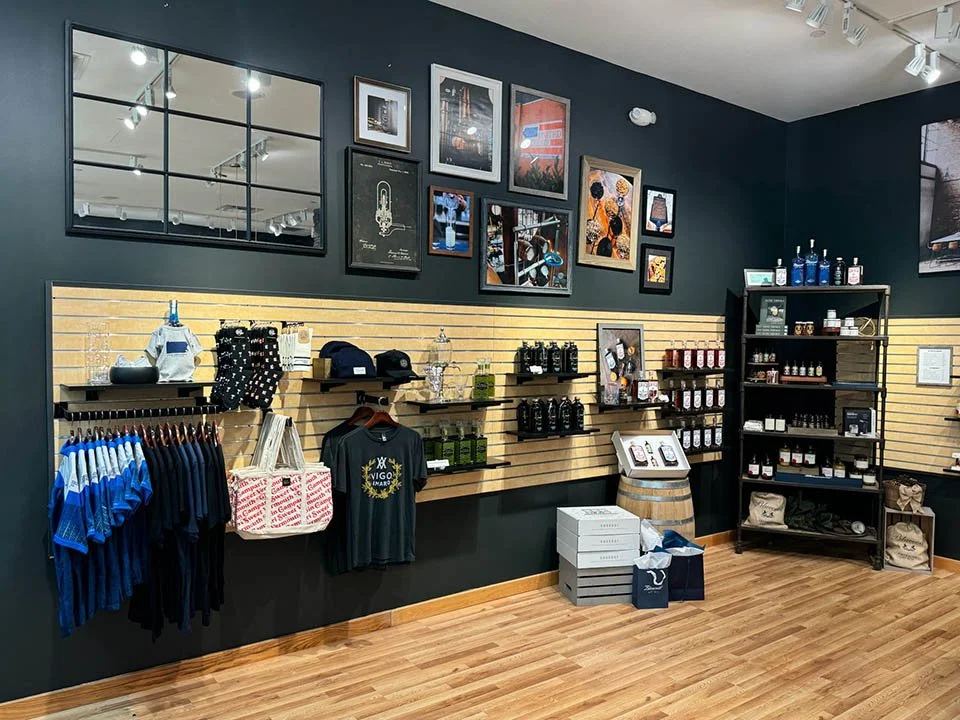 Gallery wall of images above a slat wall holding distillery products