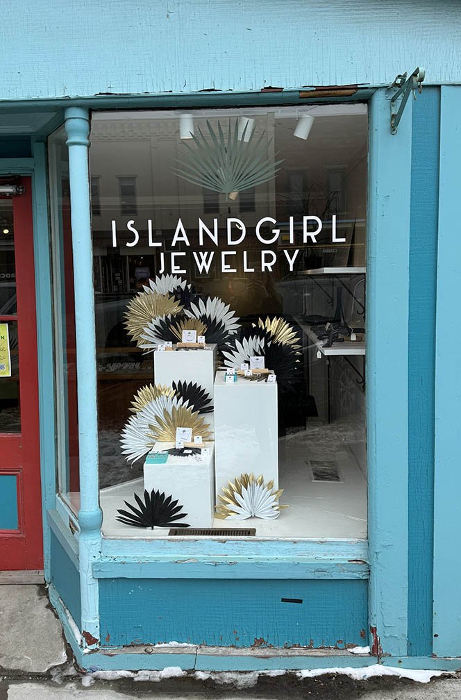 Right window display of painted palms & wooden display pedestals