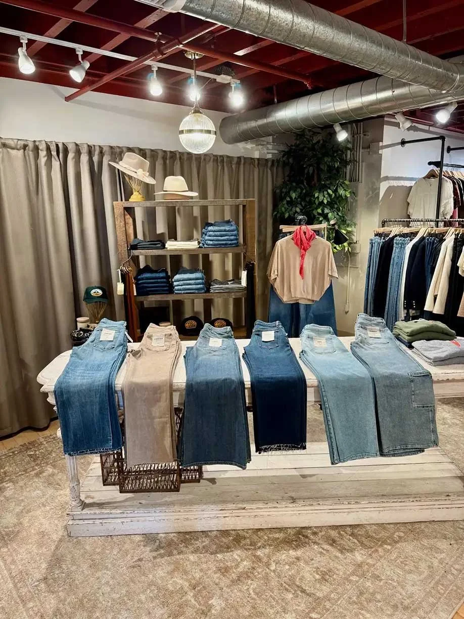 Denim bar with folded denim on shelving behind