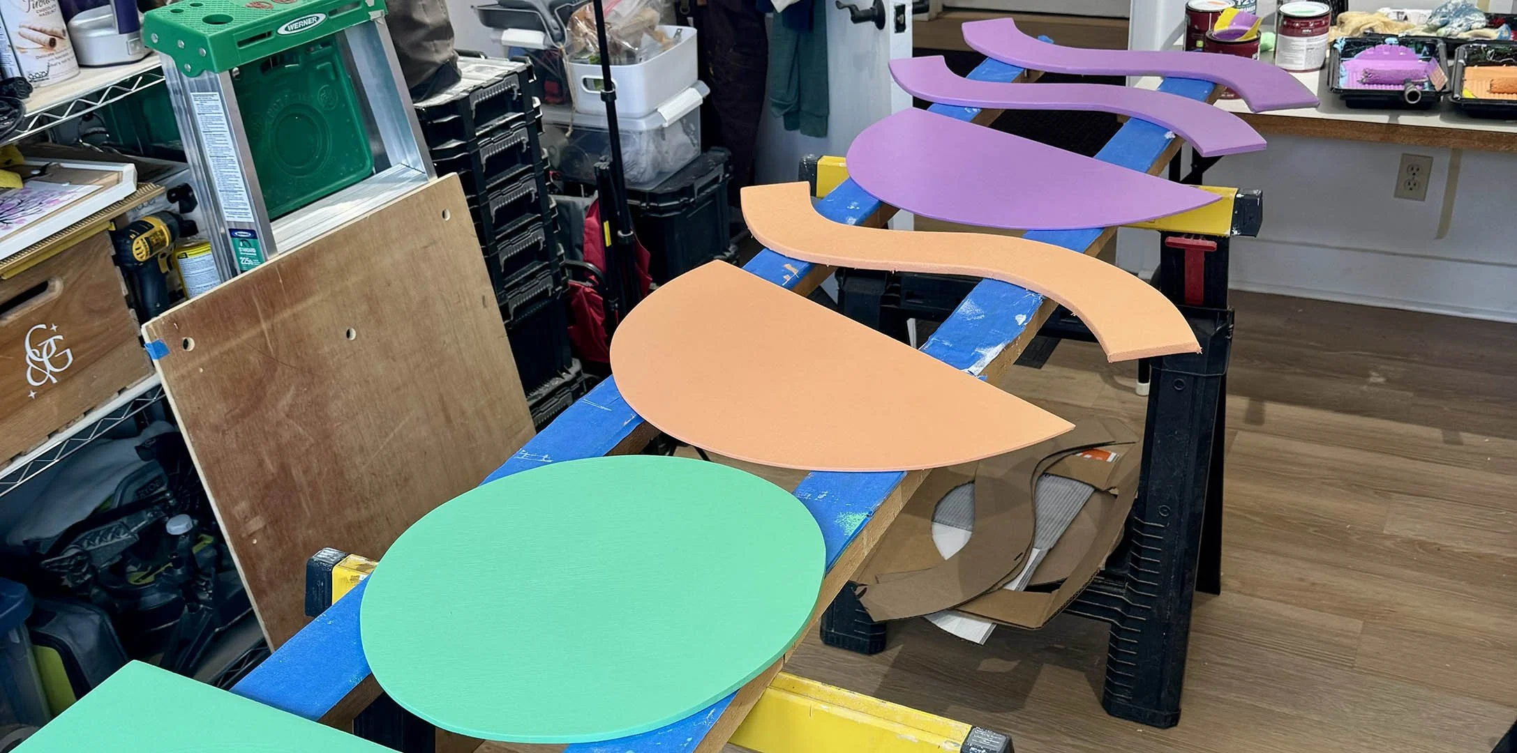 Studio process of window display shapes being painted for Sparrow art supply store