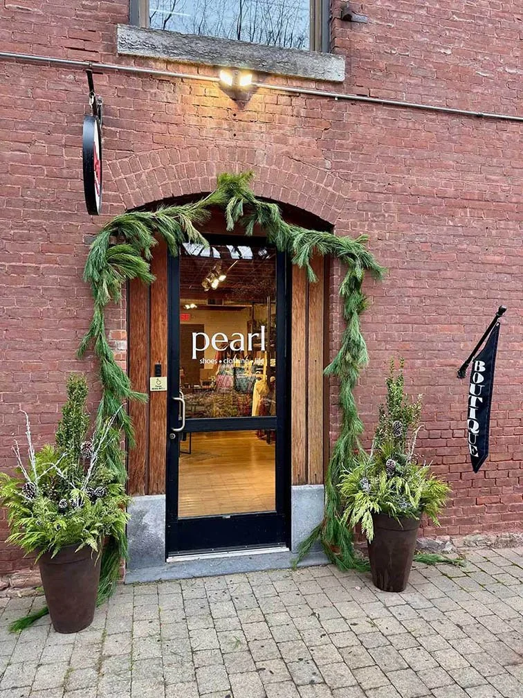 Front door of boutique decorated with winter greenery