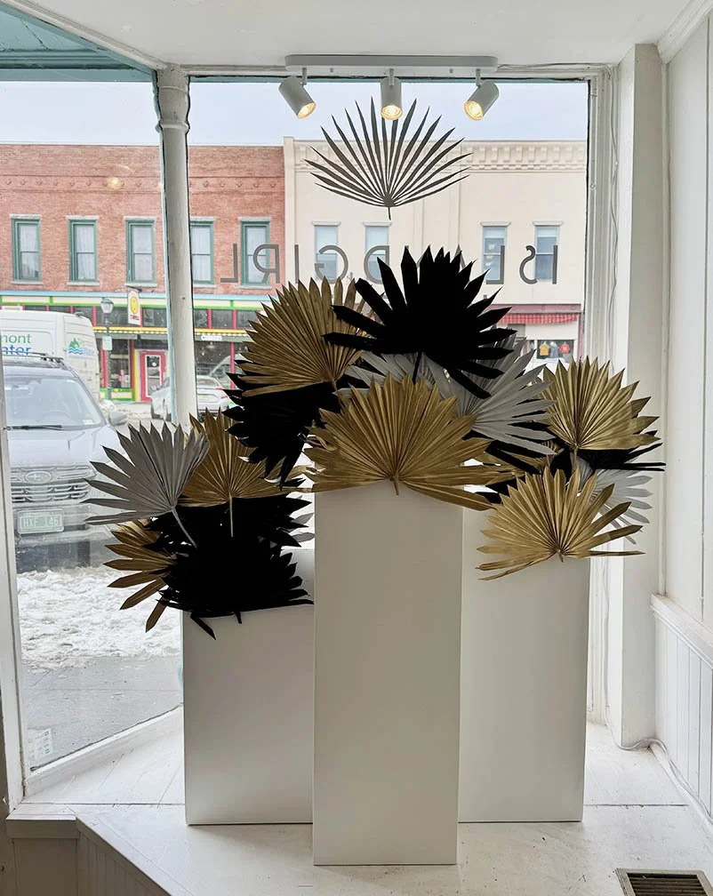 Left window interior view of palms & pedestals window display 