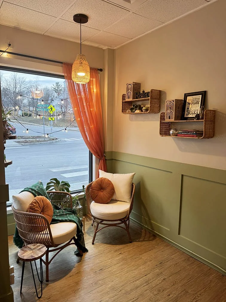 cozy nook in front window area with two chairs and shelving