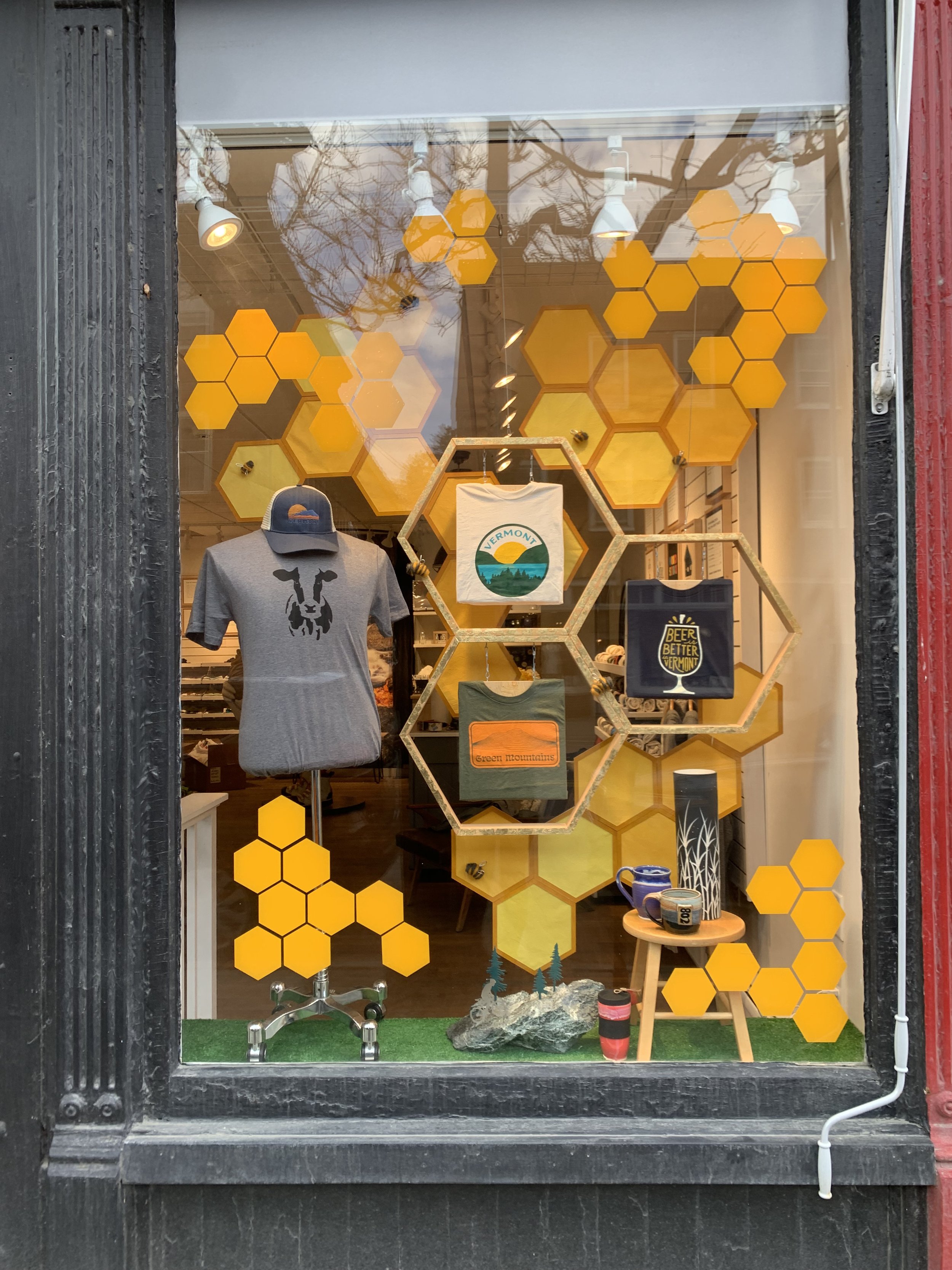 honeycomb shaped window display showcasing t-shirt designs in a storefront