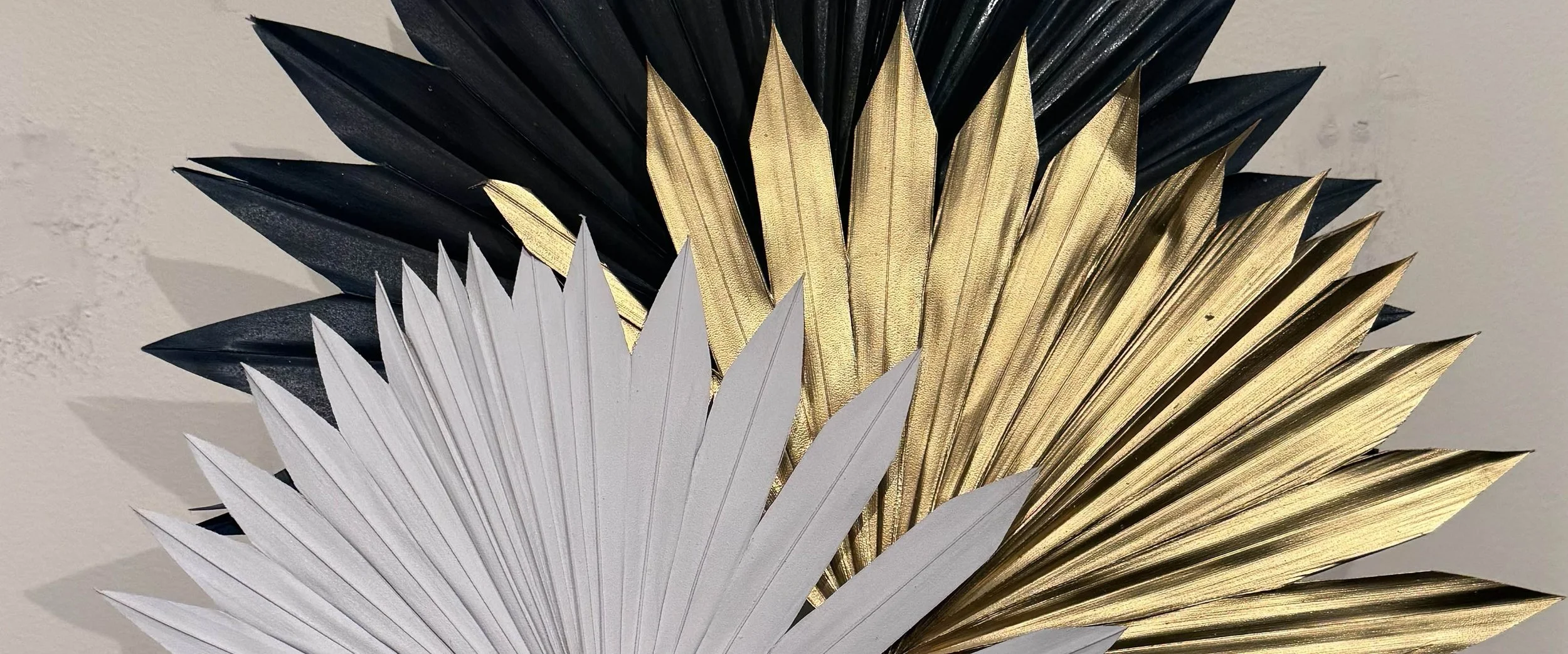 closeup of painted palm leaves in white gold and navy blue