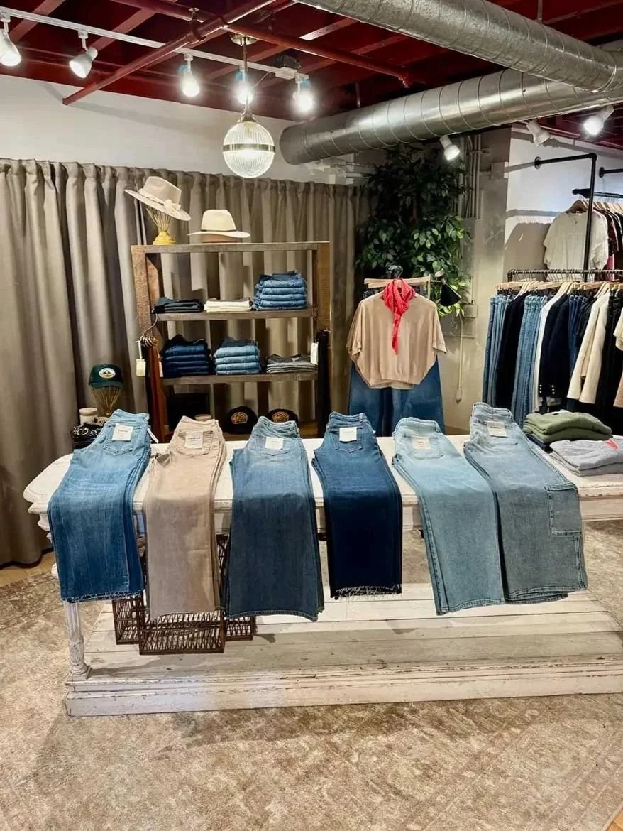 Denim bar with folded denim on shelving behind