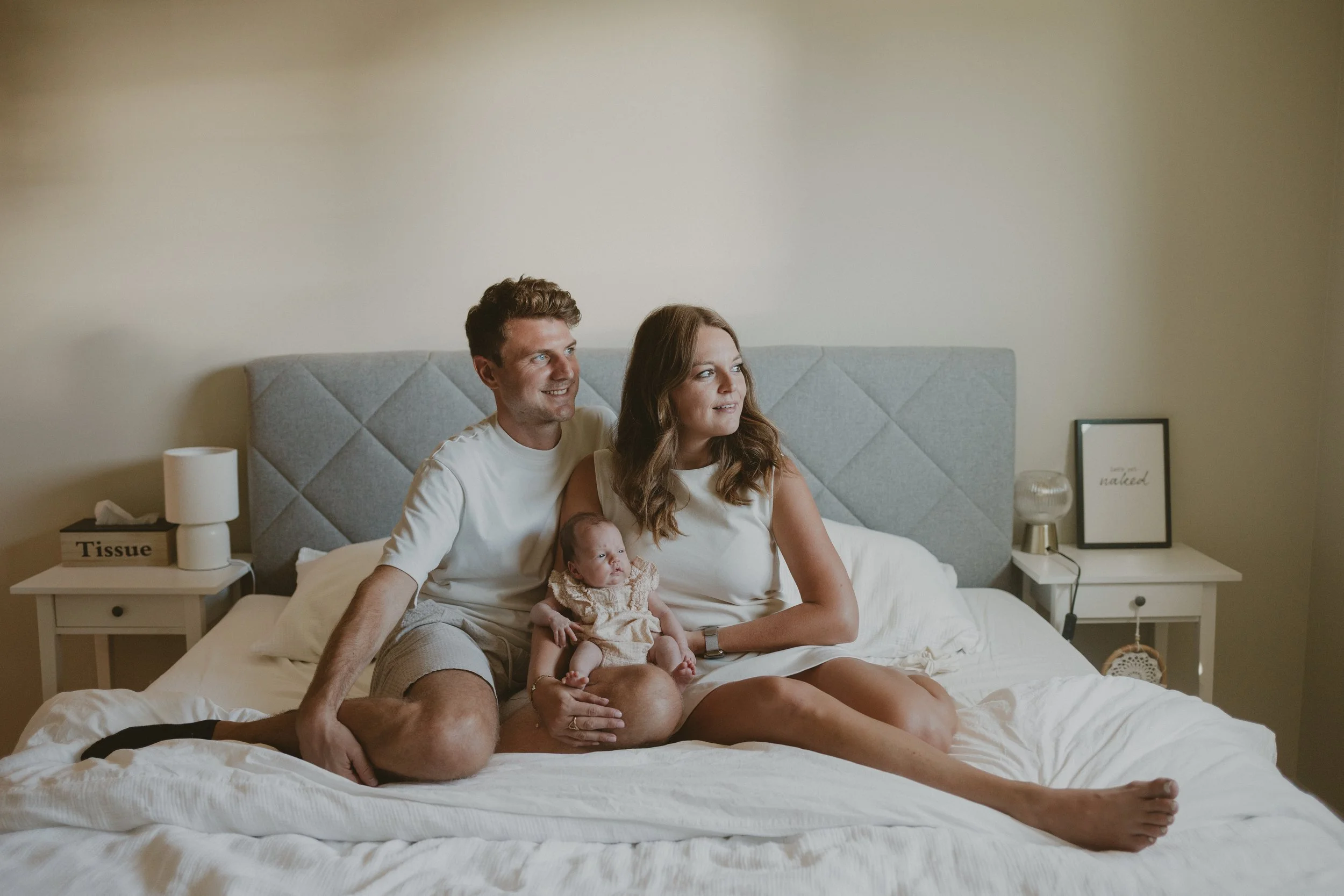Mama en papa hebben hun baby vast al zittend in hun bed.
