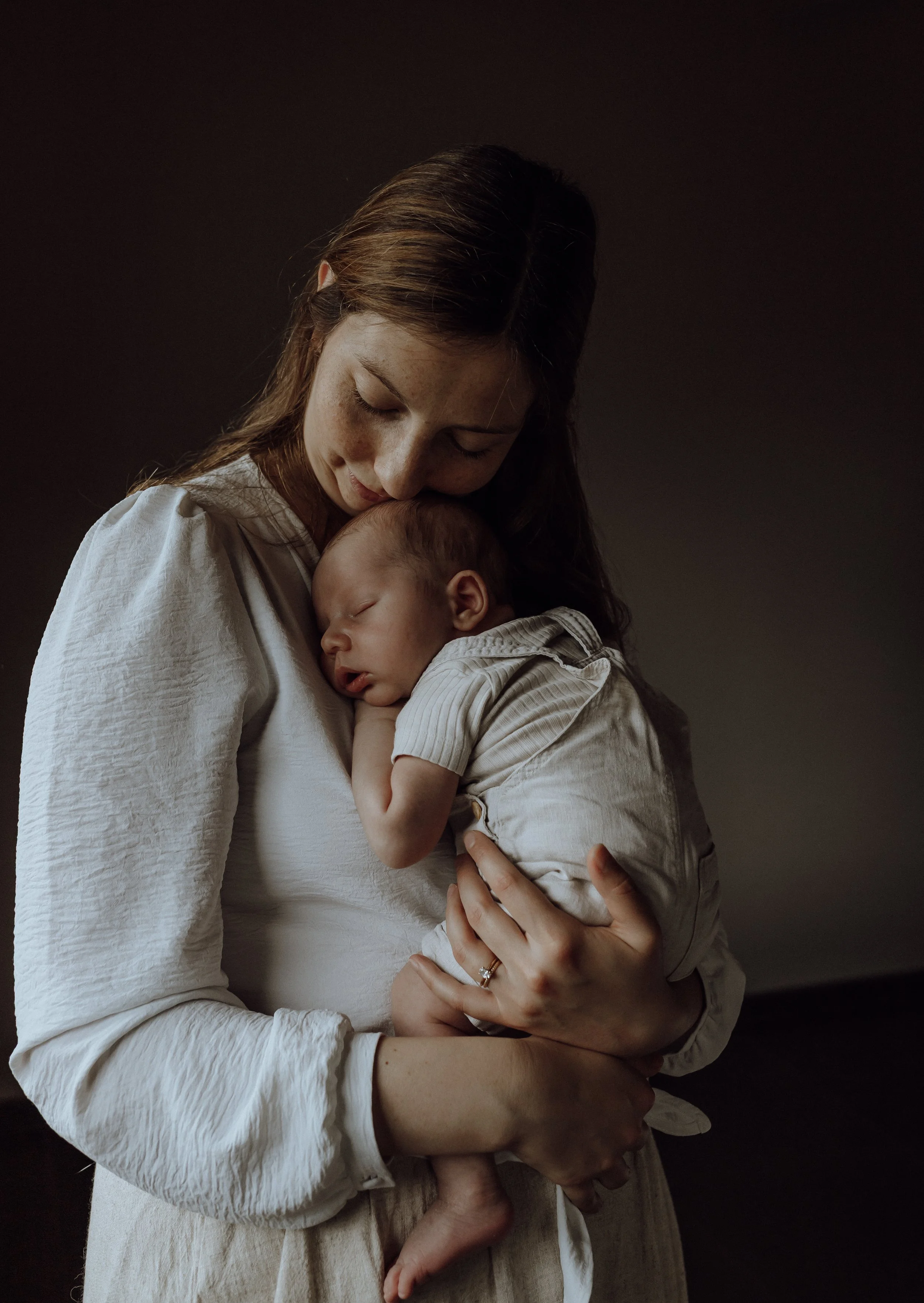Pasgeboren baby in de armen van mama tijdens een newbornshoot