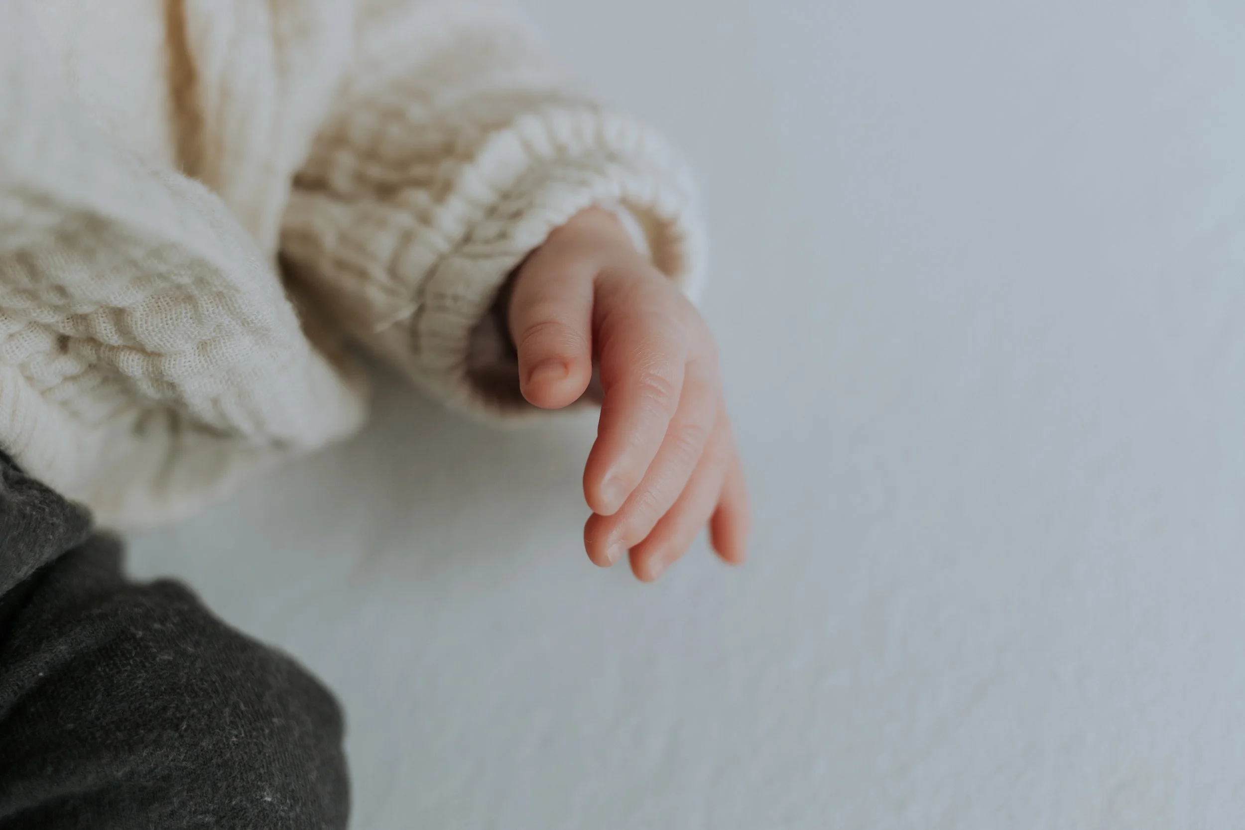 die kleine handjes van een pasgeboren baby