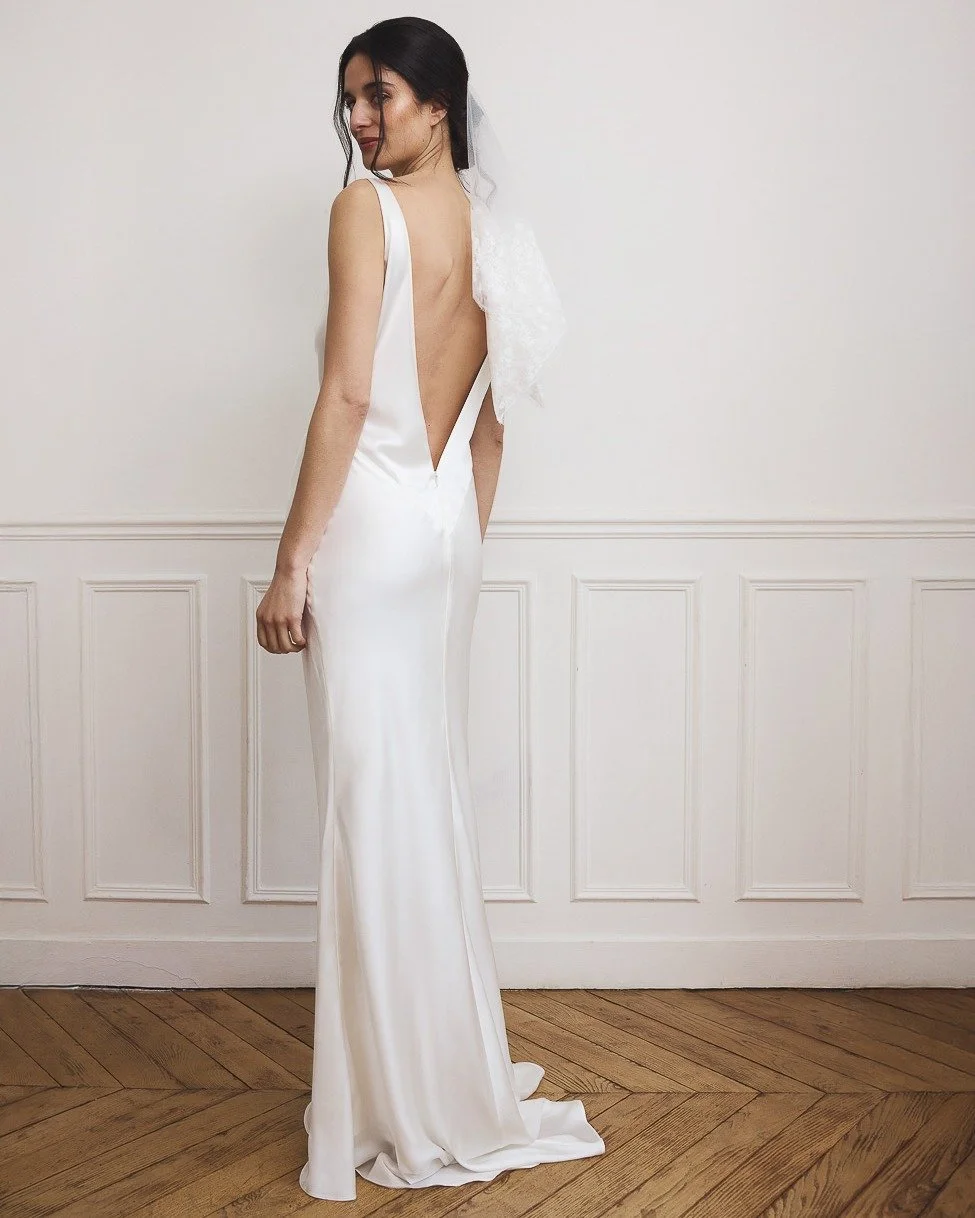 SLOANE, our bias-cut silk satin gown, drapes fluidly over the body with a soft waterfall neckline and a daring deep V-back. Paired with the delicate botanical handkerchief veil, this look is a poetic celebration of modern romance &mdash; refined, eff