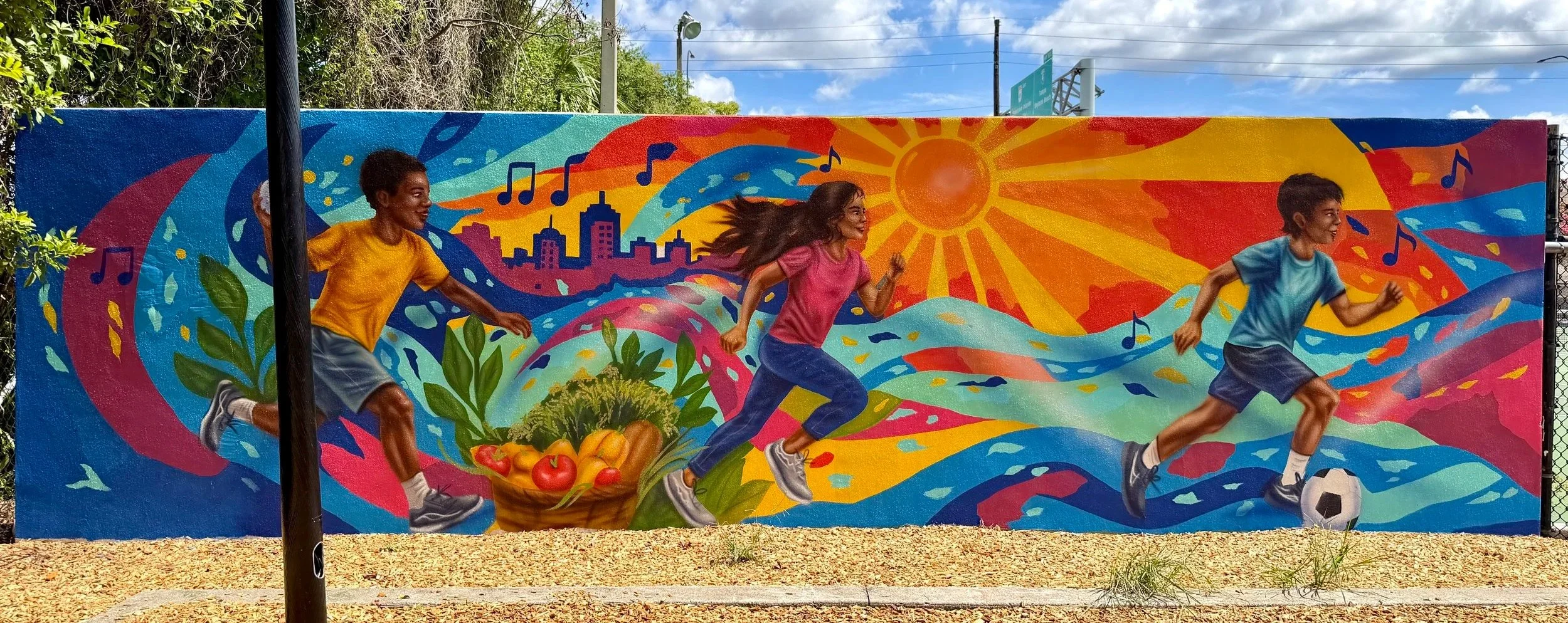City of Orlando playground mural with children running, music and neighborhood imagery