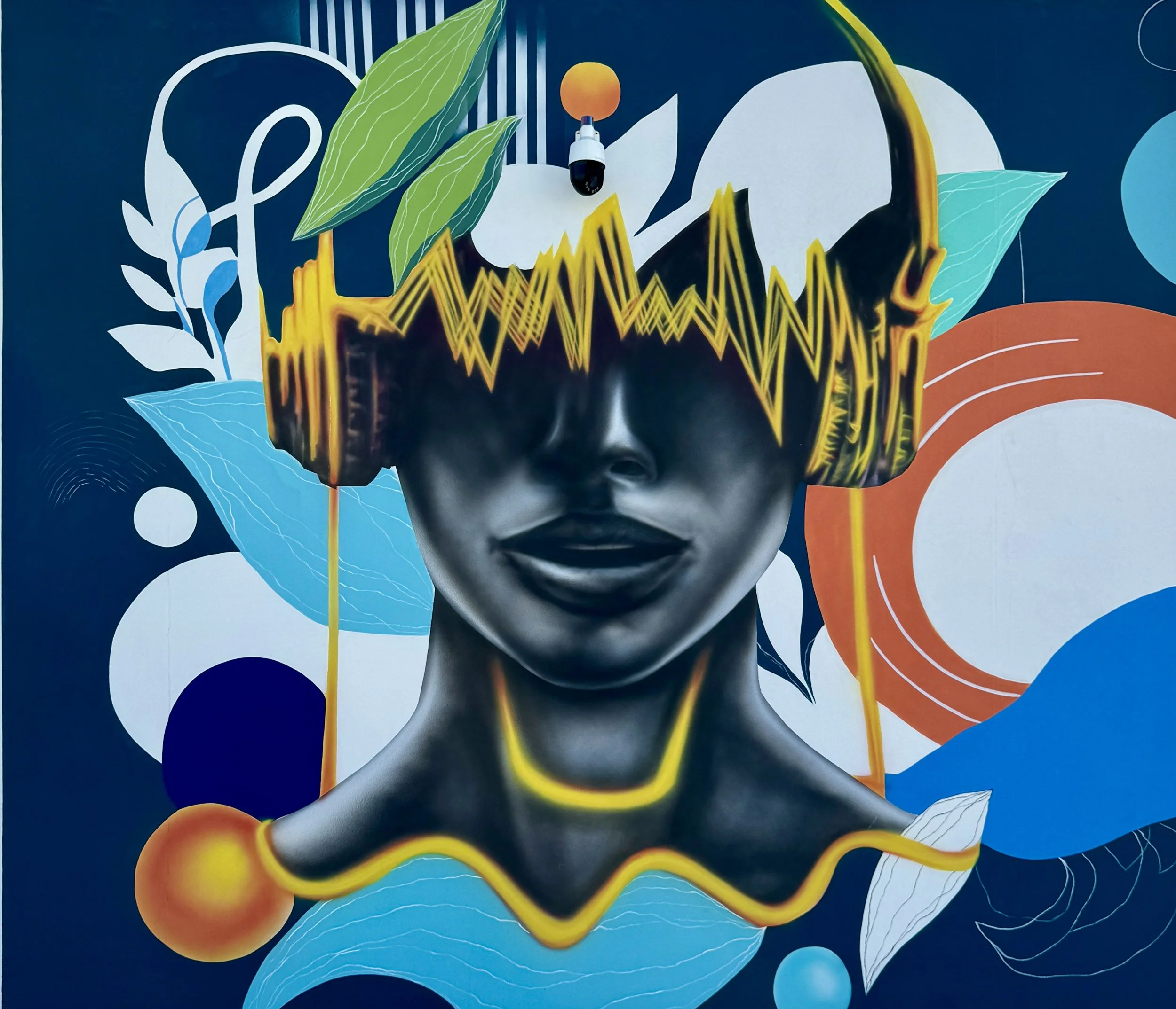 Modern Harmony mural of a woman wearing golden headphones at Thrive Art District in Fort Lauderdale