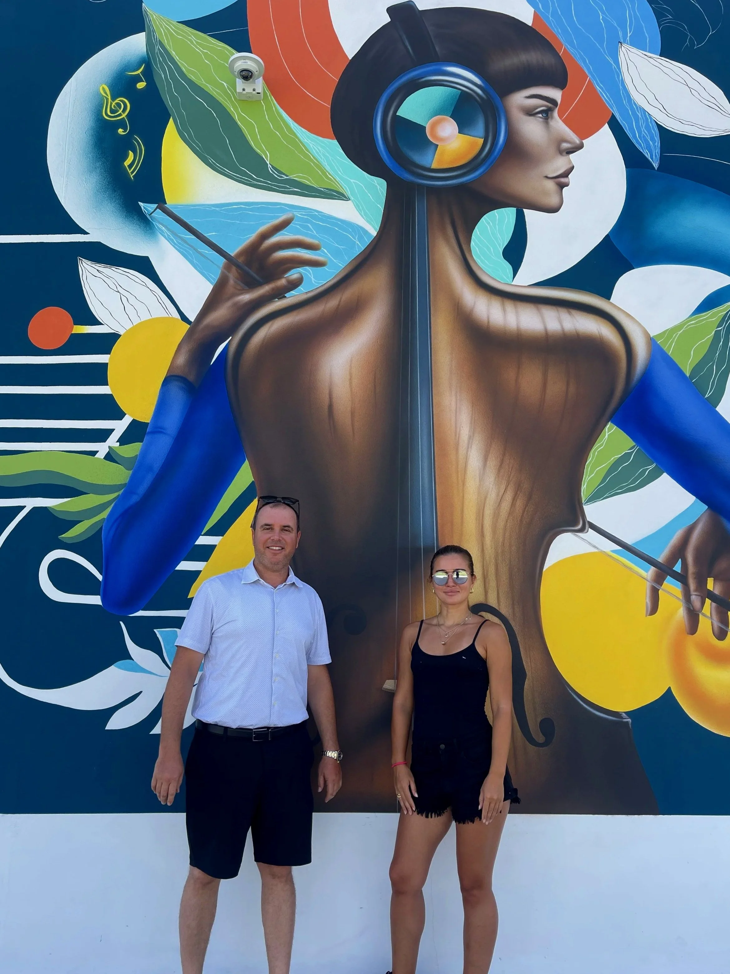 Nargiza Dadabaeva and the project client in front of the finished Thrive Art District mural