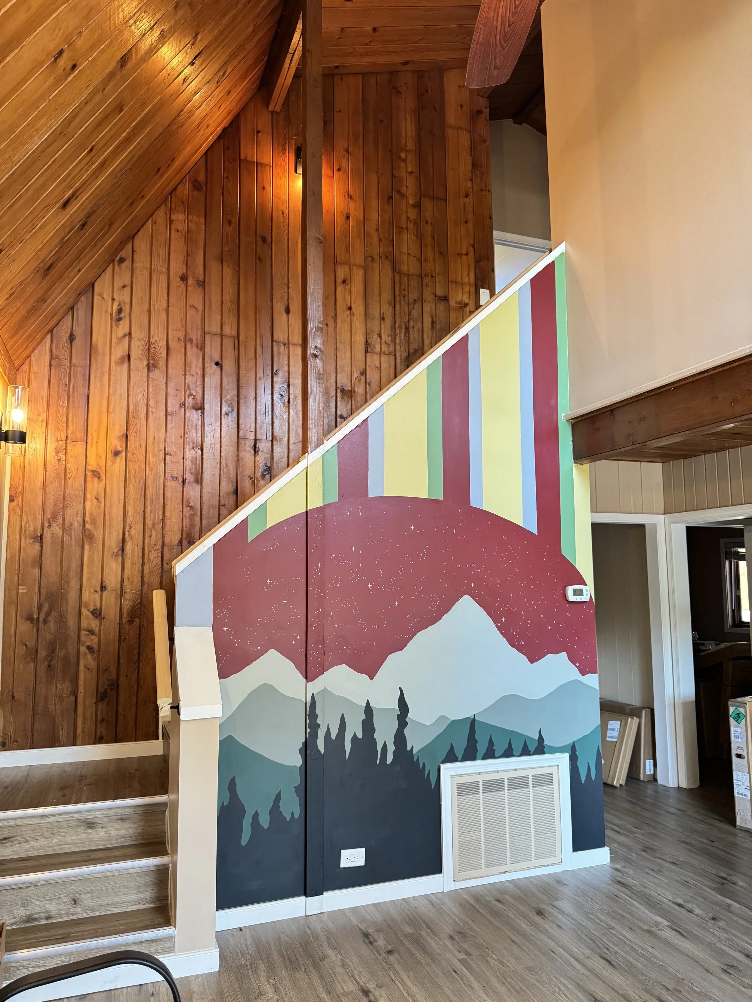 Completed colorful mountain mural on the stairway wall of a Virginia Airbnb