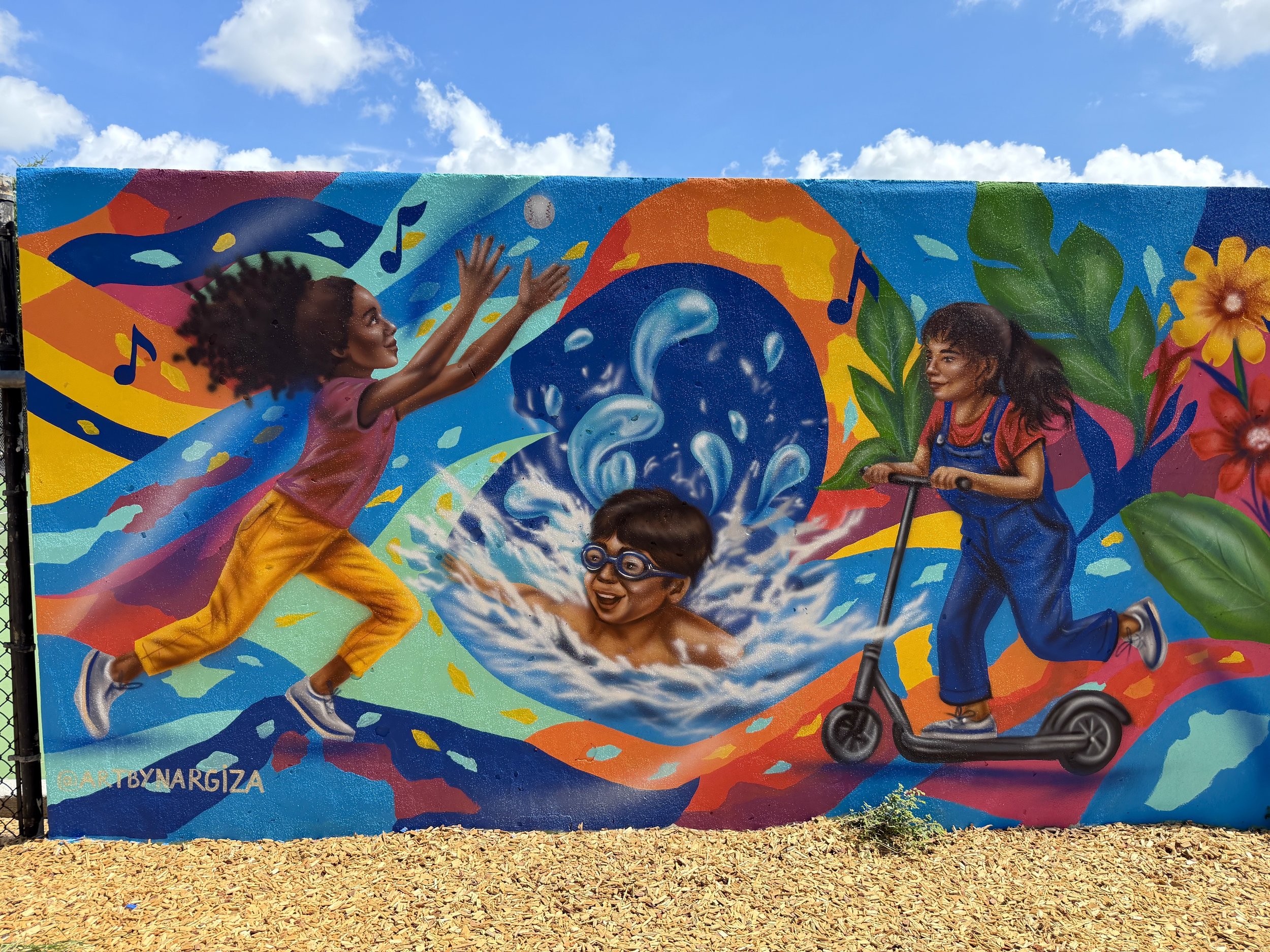 Children playing in a vibrant community mural at the John H. Jackson Neighborhood Center Playground in Orlando.