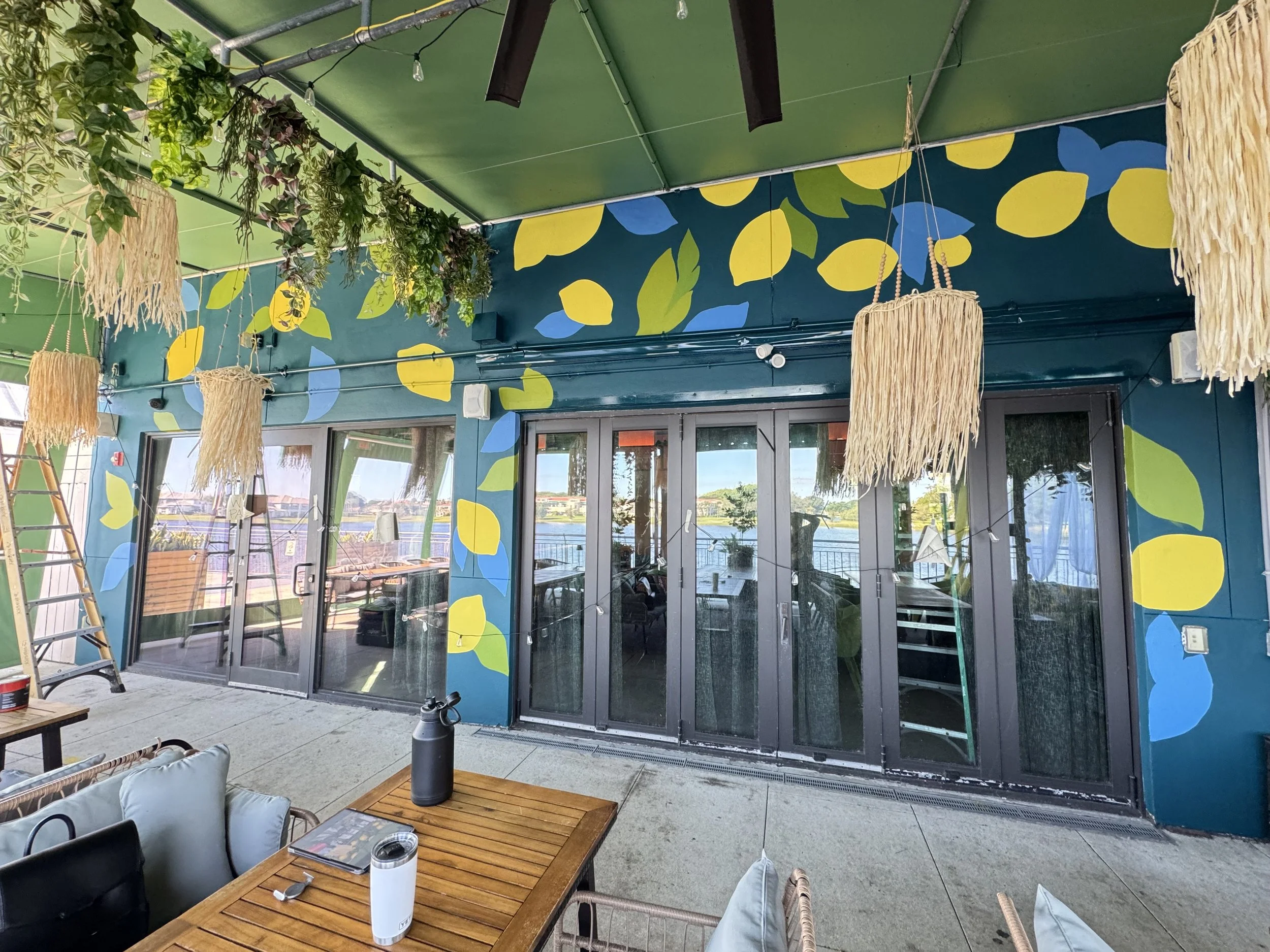 Blue and yellow lemon mural on a waterfront restaurant patio
