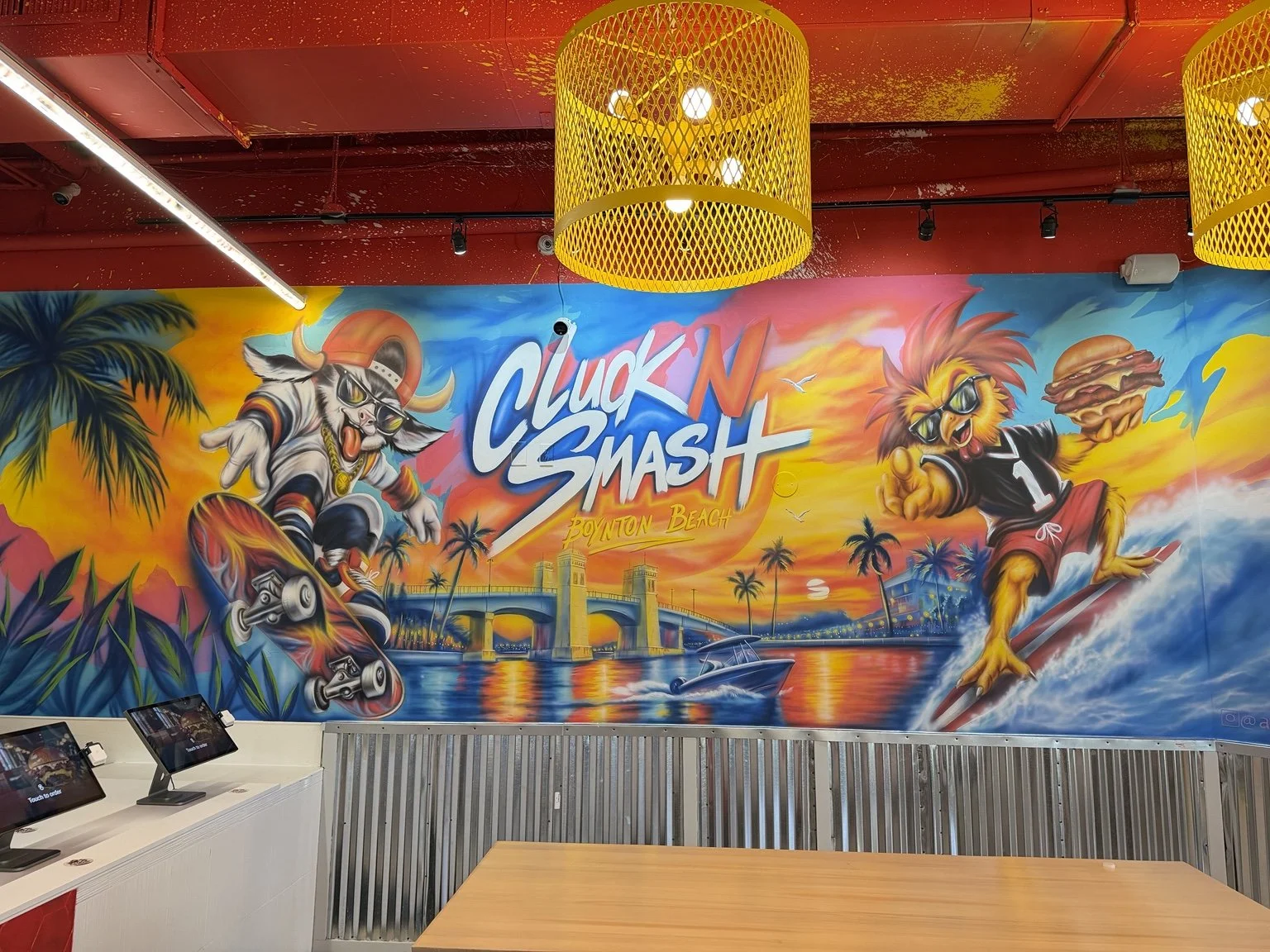 Completed Cluck N Smash restaurant mural in Boynton Beach, Florida, painted by Art by Nargiza