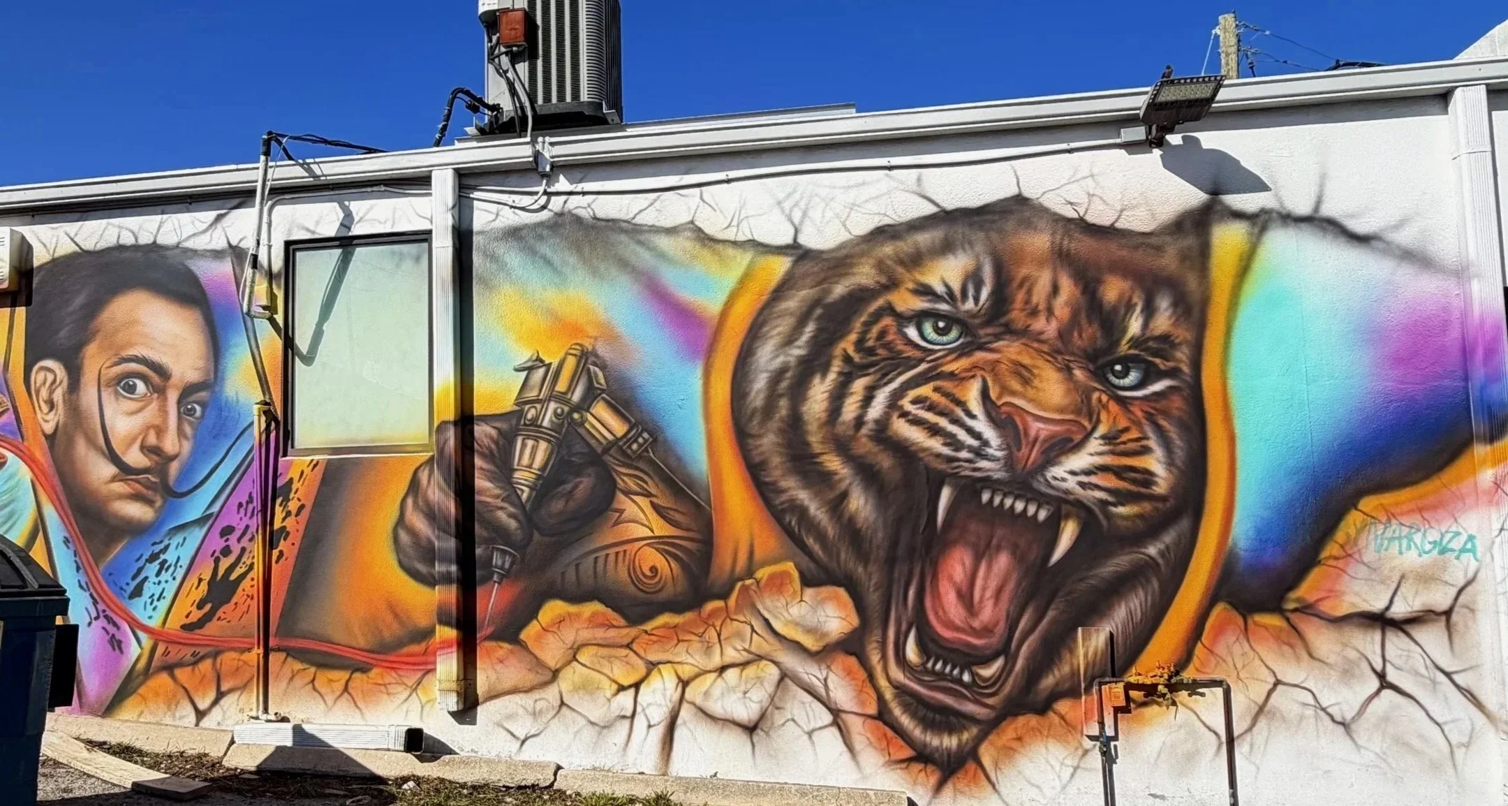 Exterior mural featuring Salvador Dalí, tattoo imagery and a roaring tiger