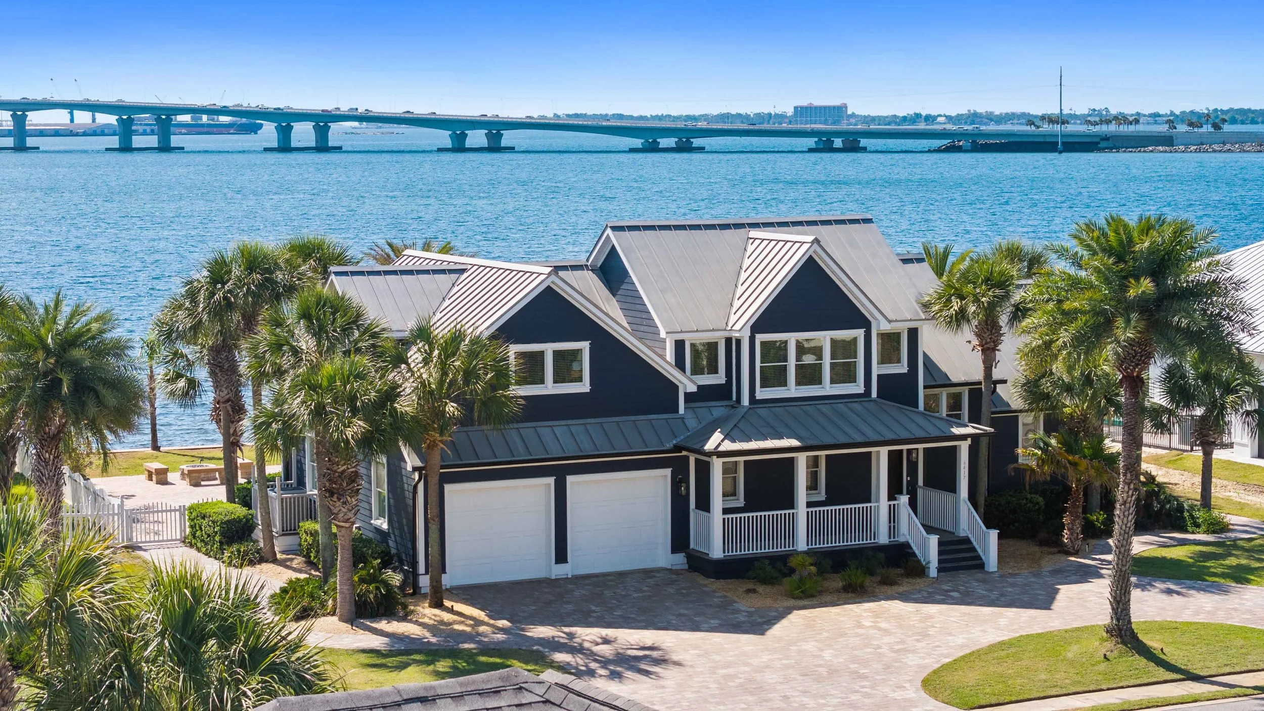 Drone photo of a real estate listing in Panama City Beach, showcasing a home with views of the Hathaway bridge and bay