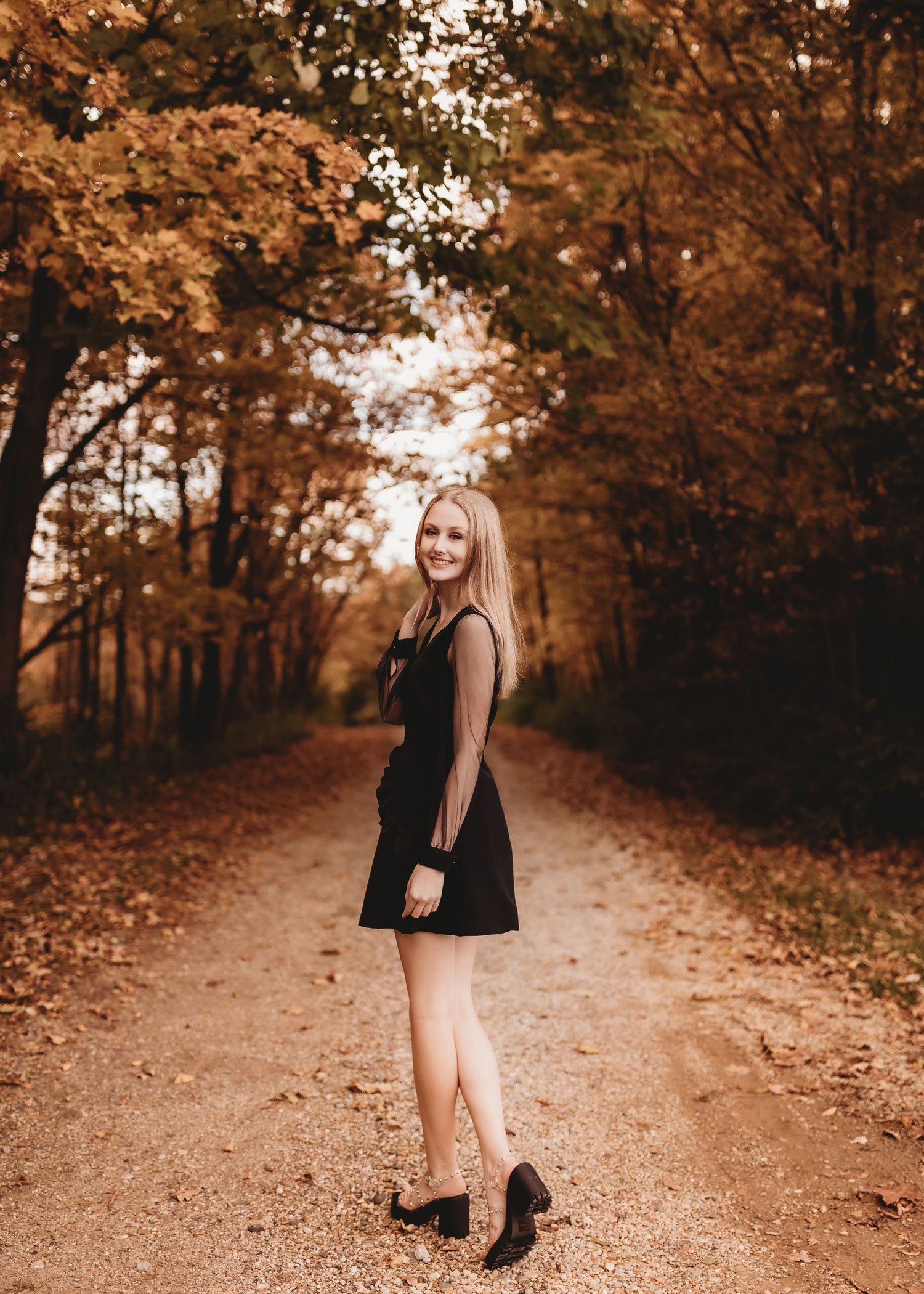 Teen girl poses best to a tree. Autumn fall portrait by Nancy Brennan.  Photo stock - StudioNow