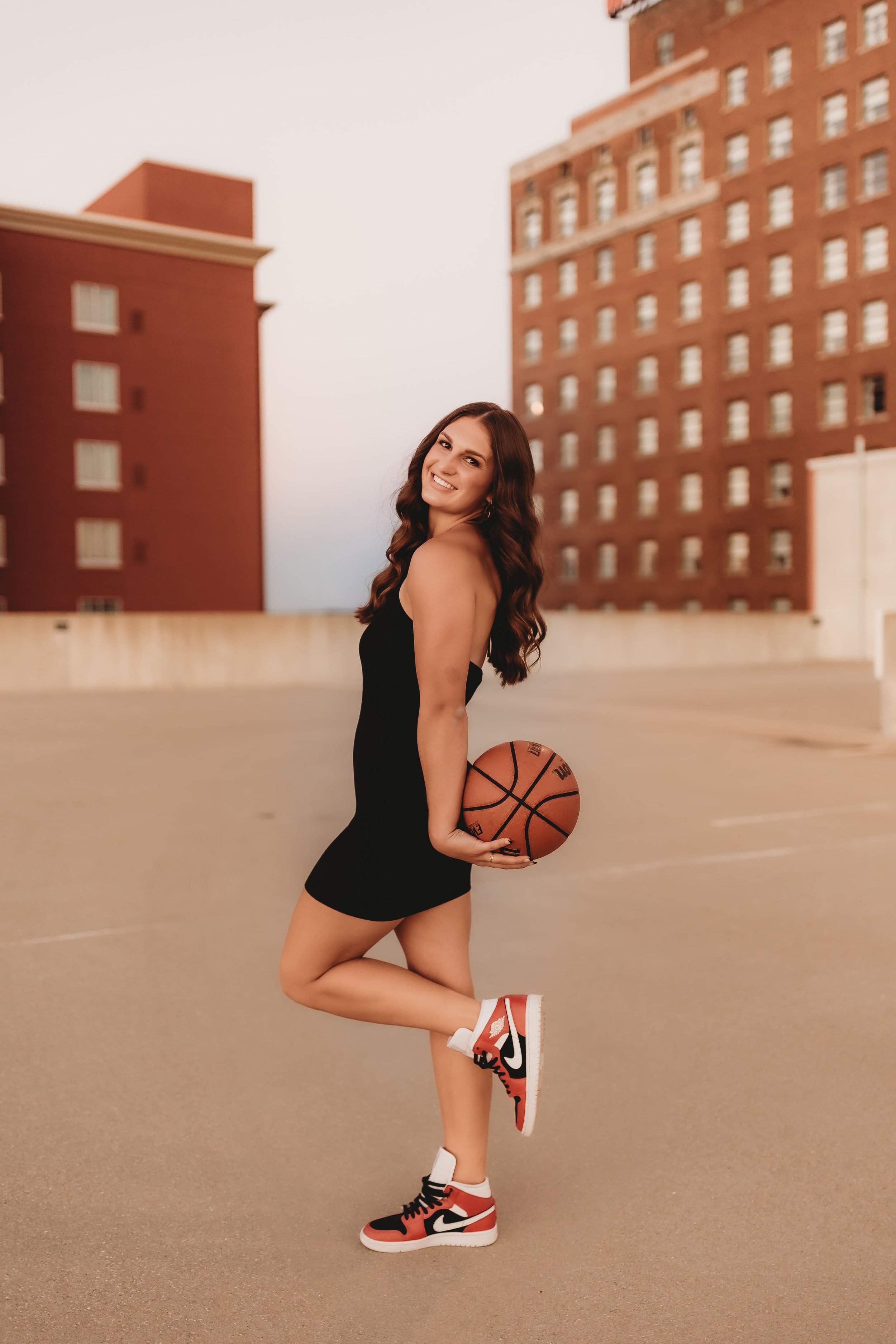  Senior basketball player for metamora stands on a peoria rooftop while holding a basketball smiling and posing for senior pictures basketball 