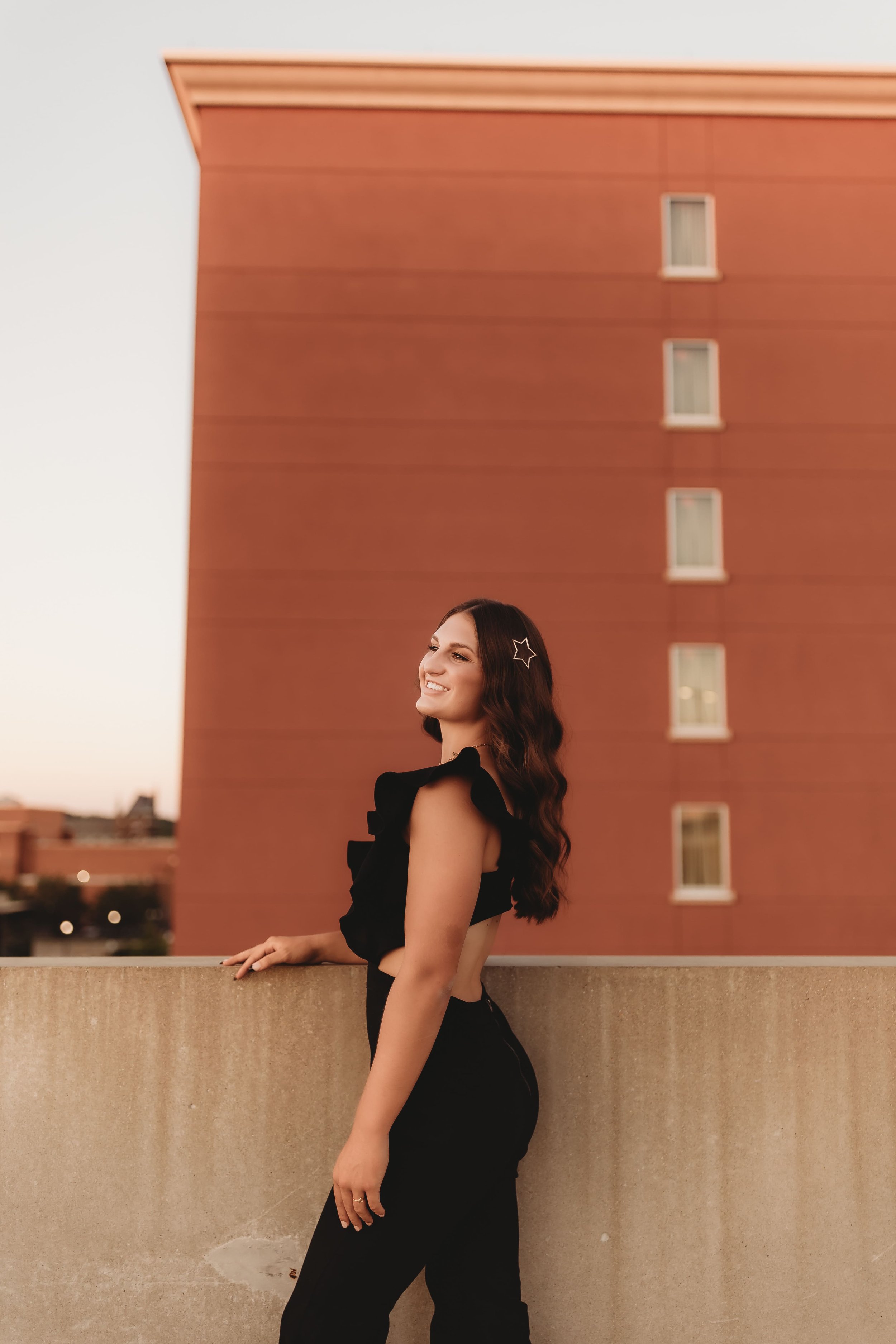  Metamora illinois high school senior stands on a rooftop and looks off into the distance while posing for senior photographer near me always flourishing photography 