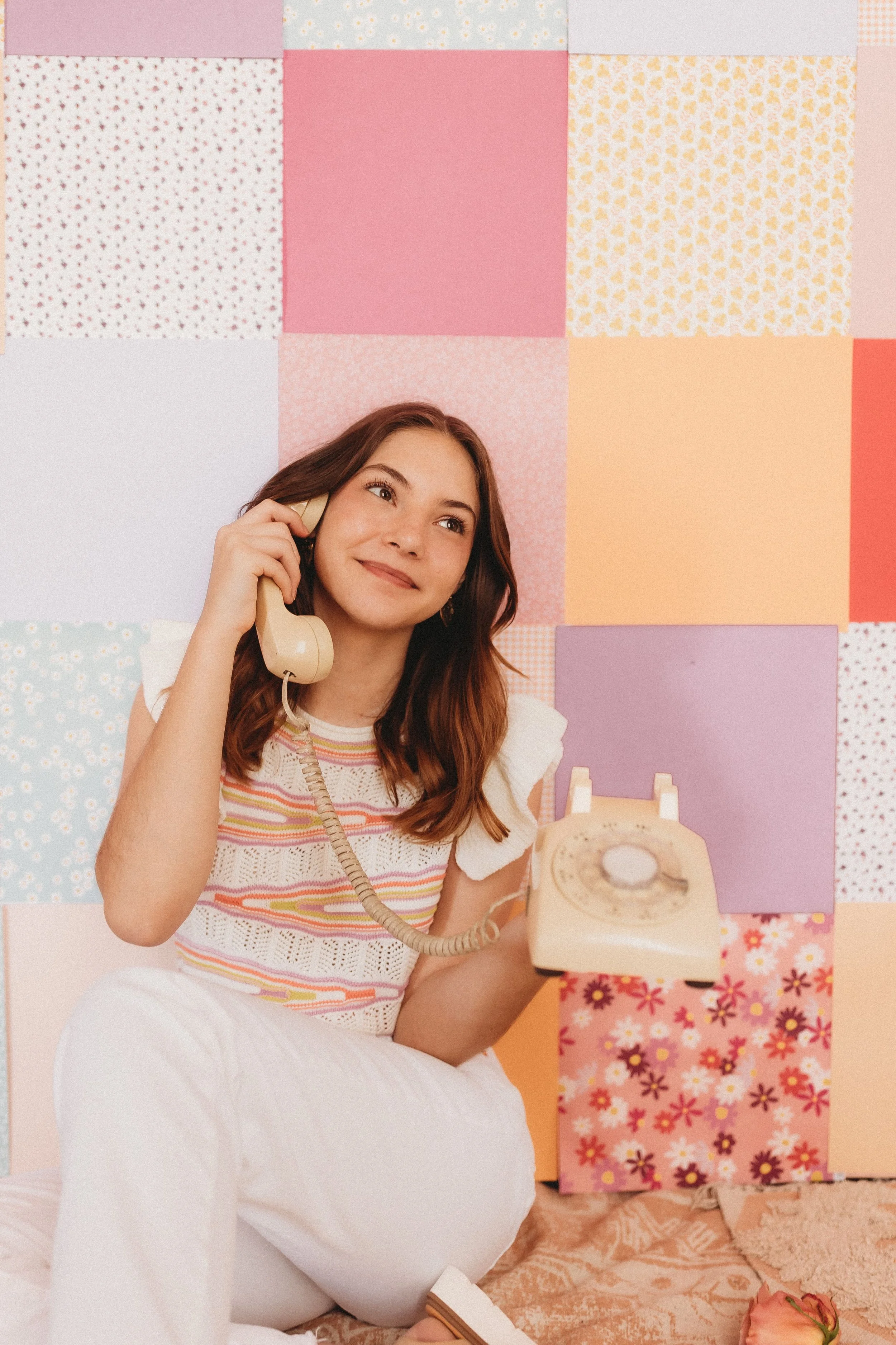  a girl holds a dial telephone posing for unique senior picture ideas 