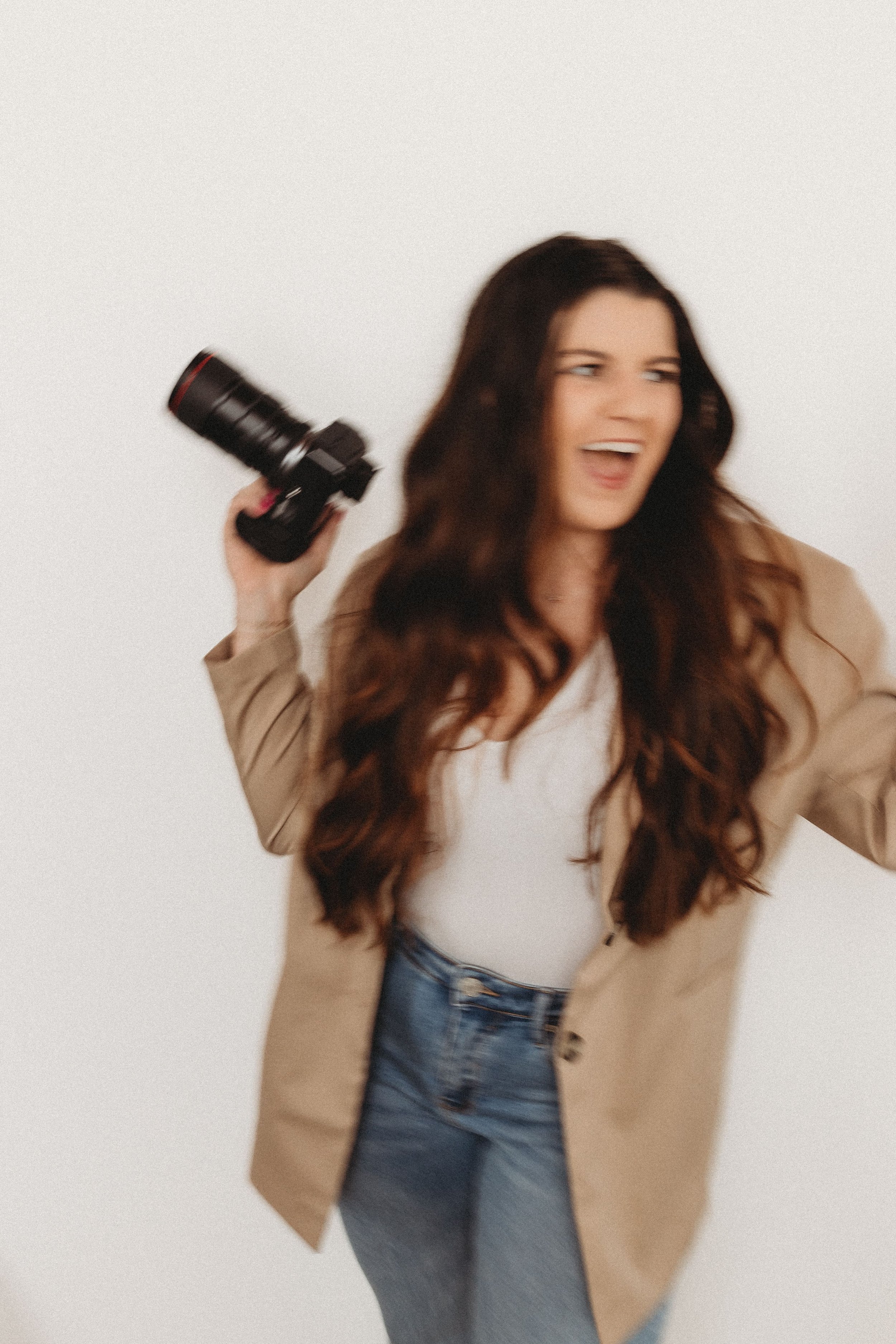  hannah laughs with her camera in hand in this motion blur portrait from her brand photos 