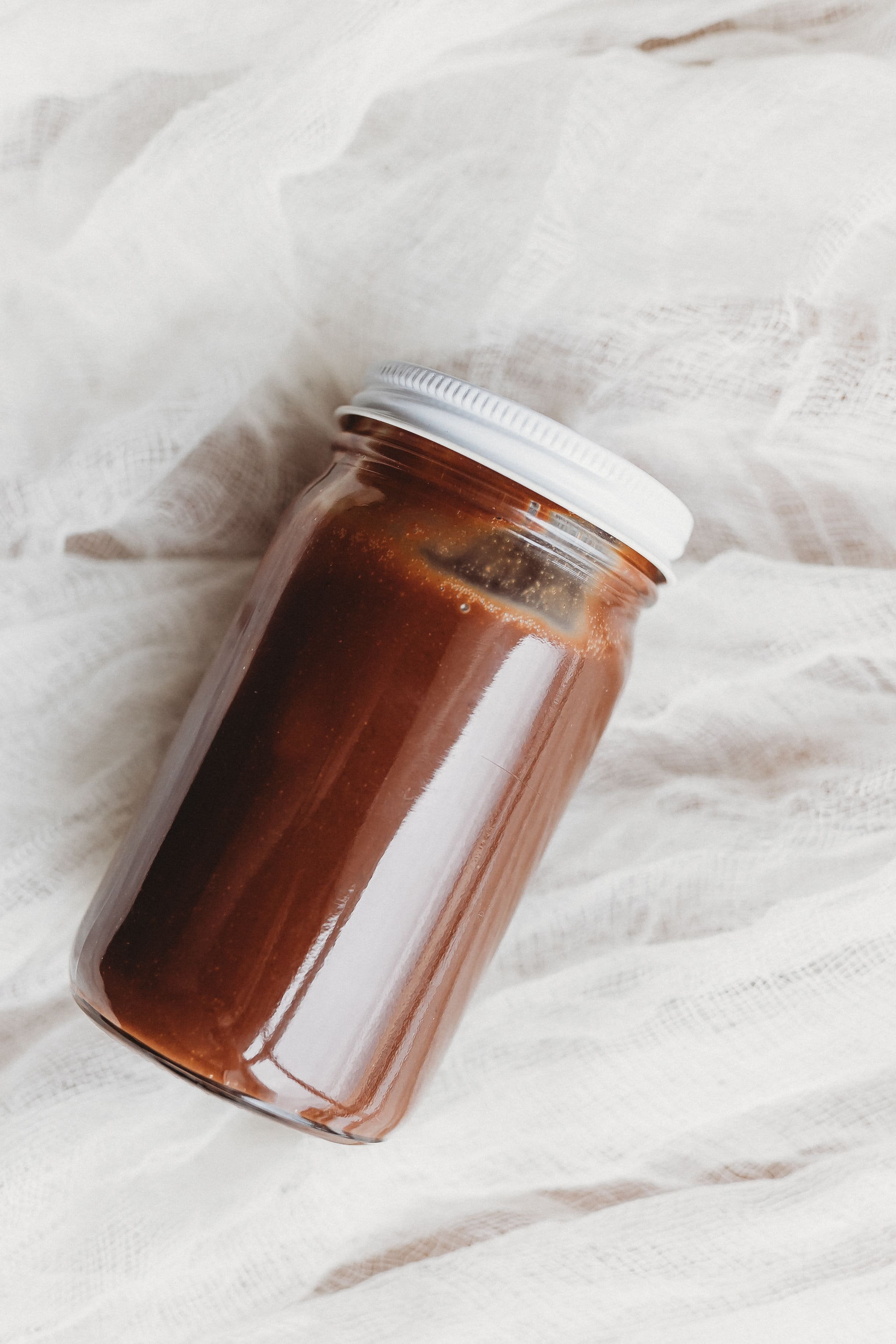  chocolate hazelnut spread in a jar rests on a marble surface during a food product photography 