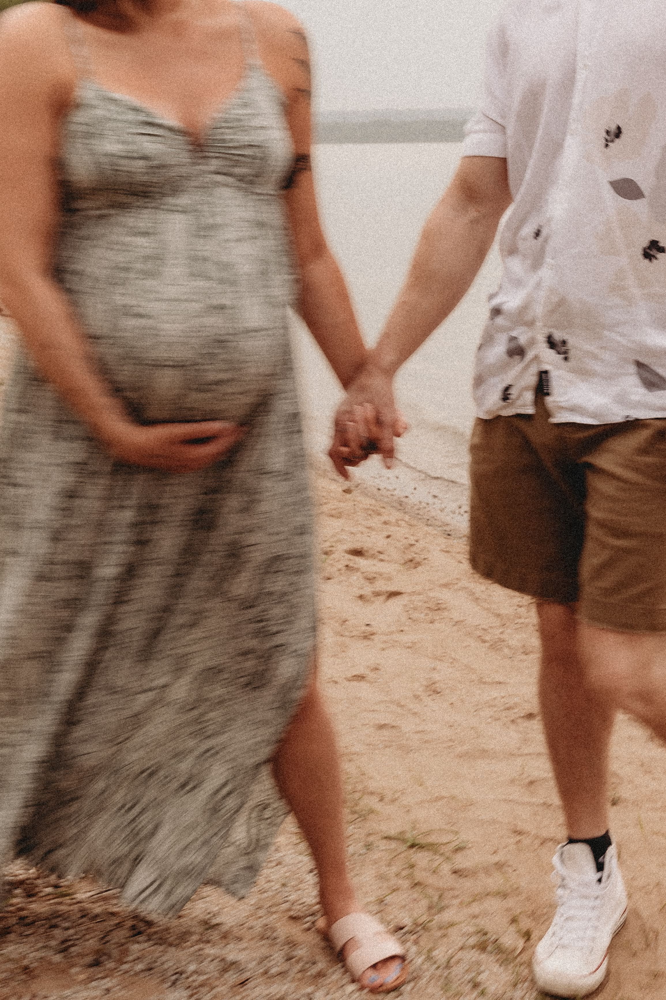  a blurred photo of an expecting couple on the beach 