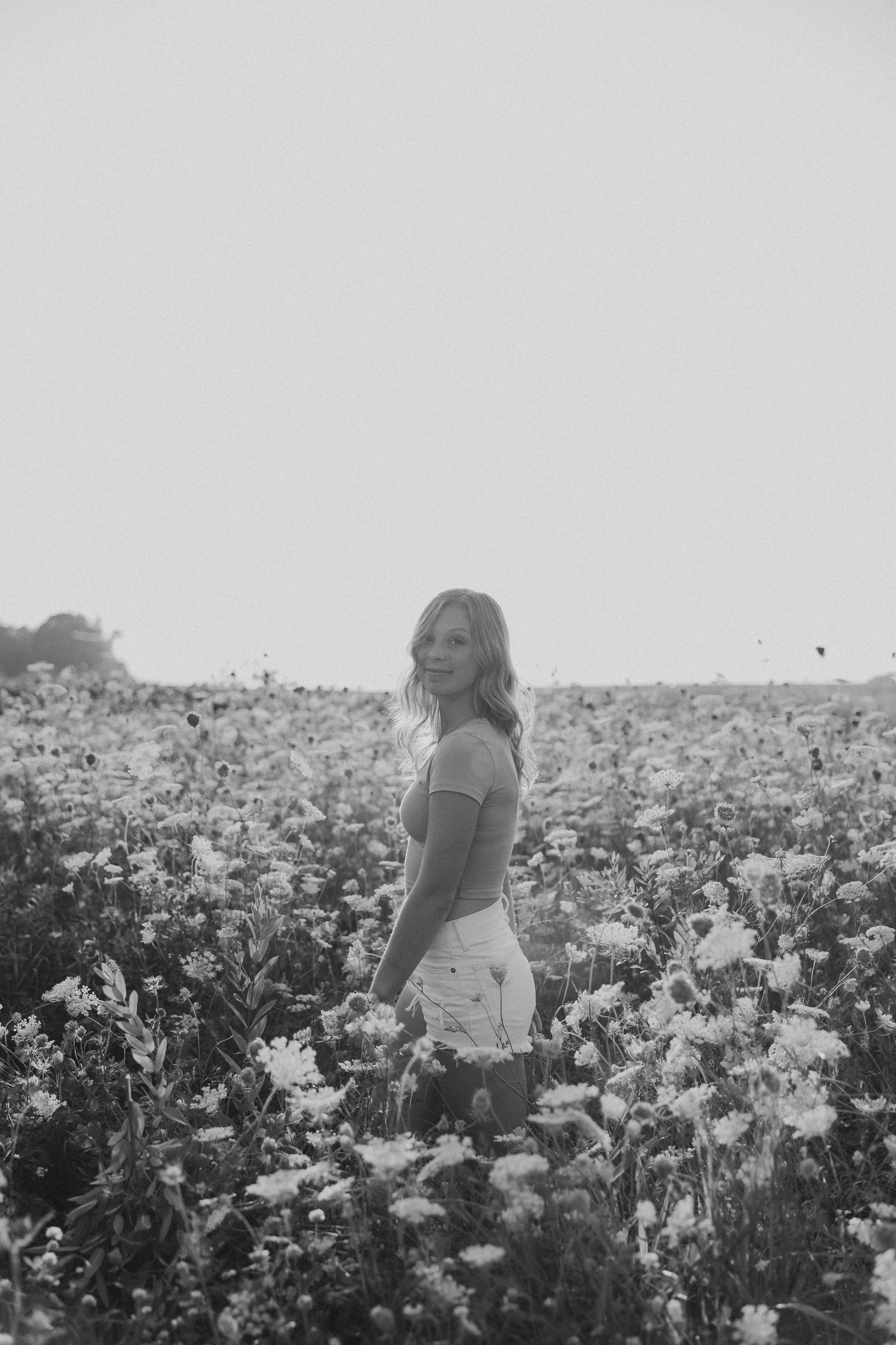  senior portrait of a young woman in a field of wildflowers 