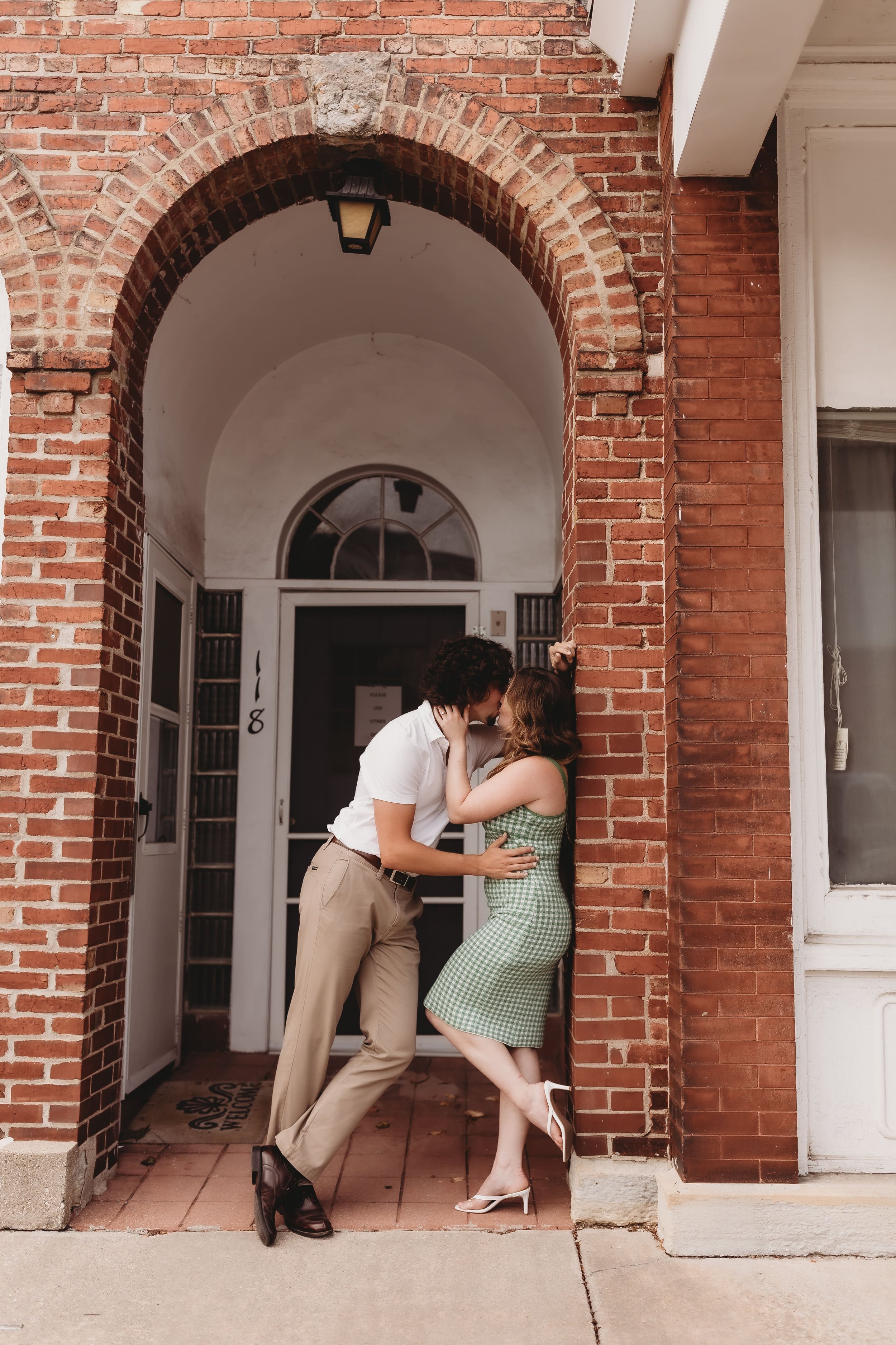  a couple lean against bricks during an outdoor session with an engagement photographer 