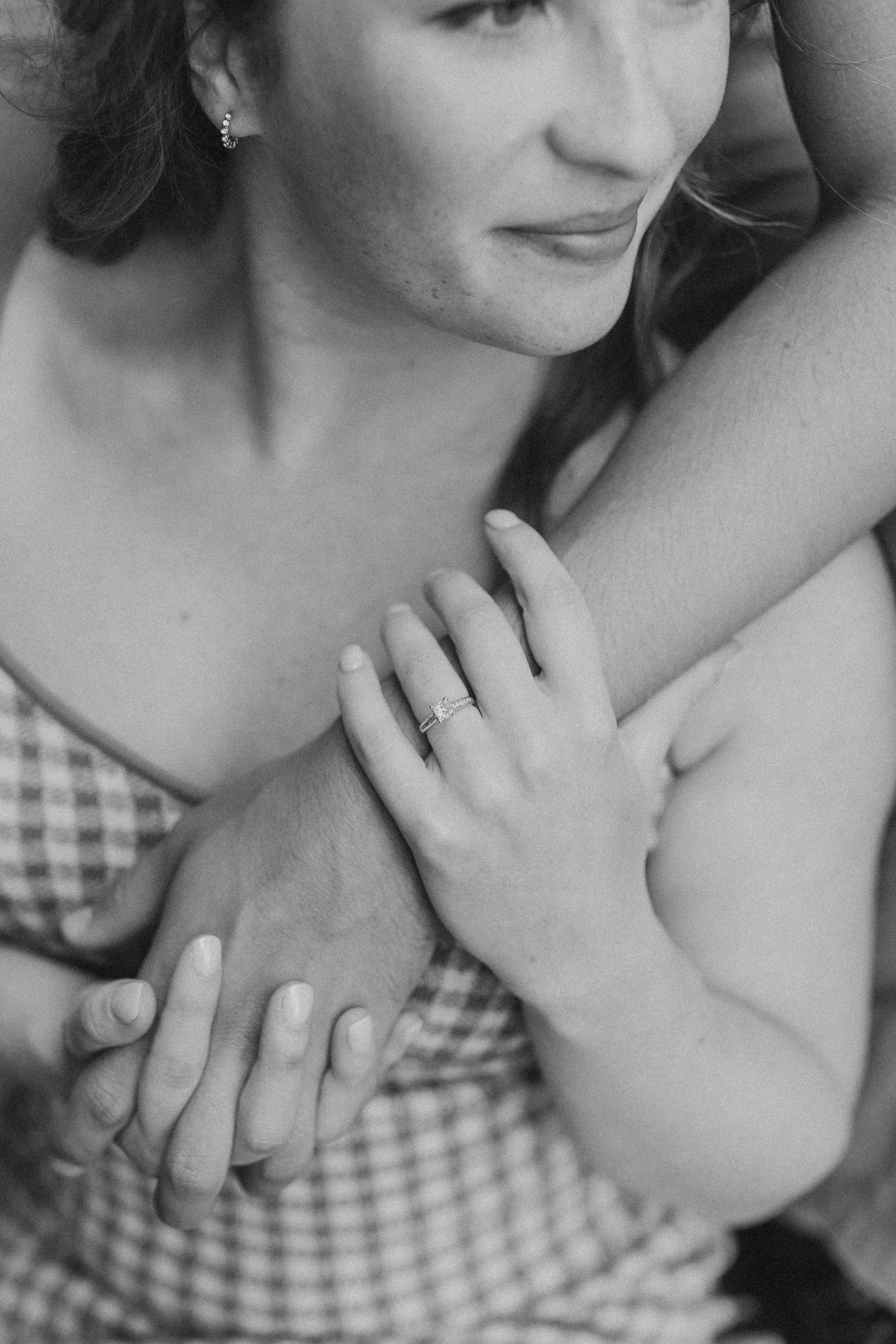  a couple hold hands in this closeup of their hands during a session with an engagement photographer 
