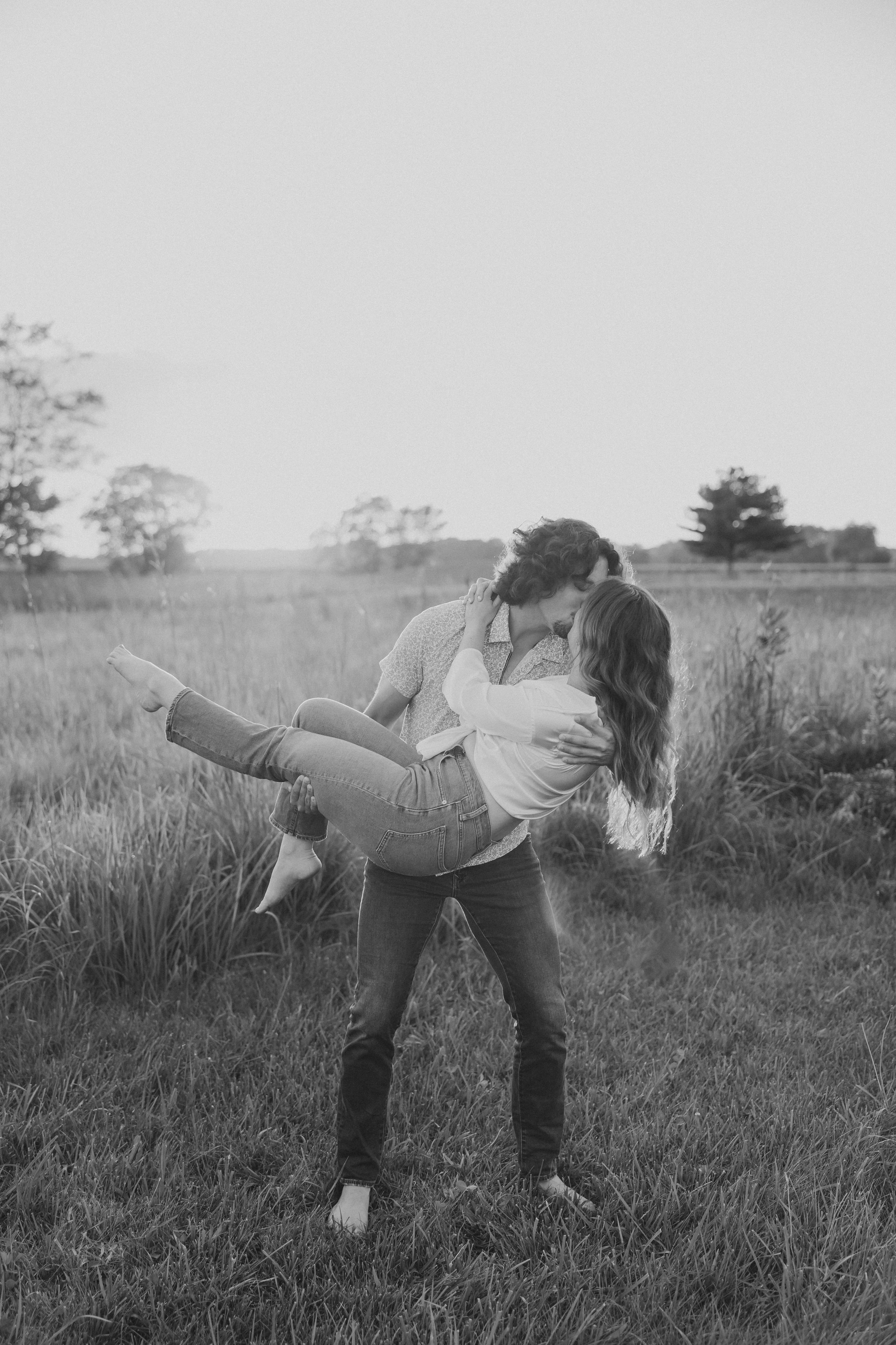  an engaged couple share a dramatic kiss in a field  