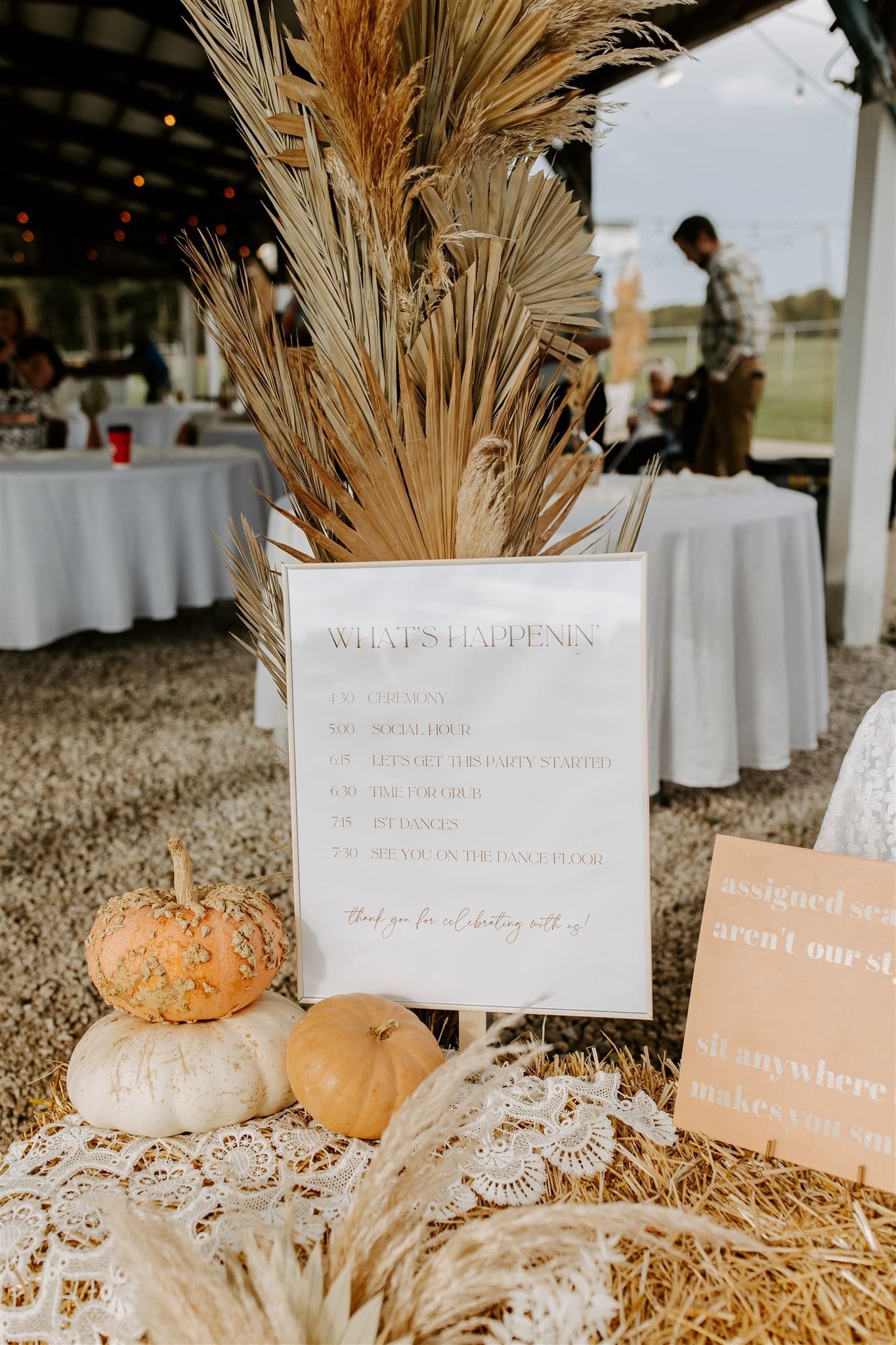  boho wedding signage, a wedding timeline sign sits next to pumpkins and lace 