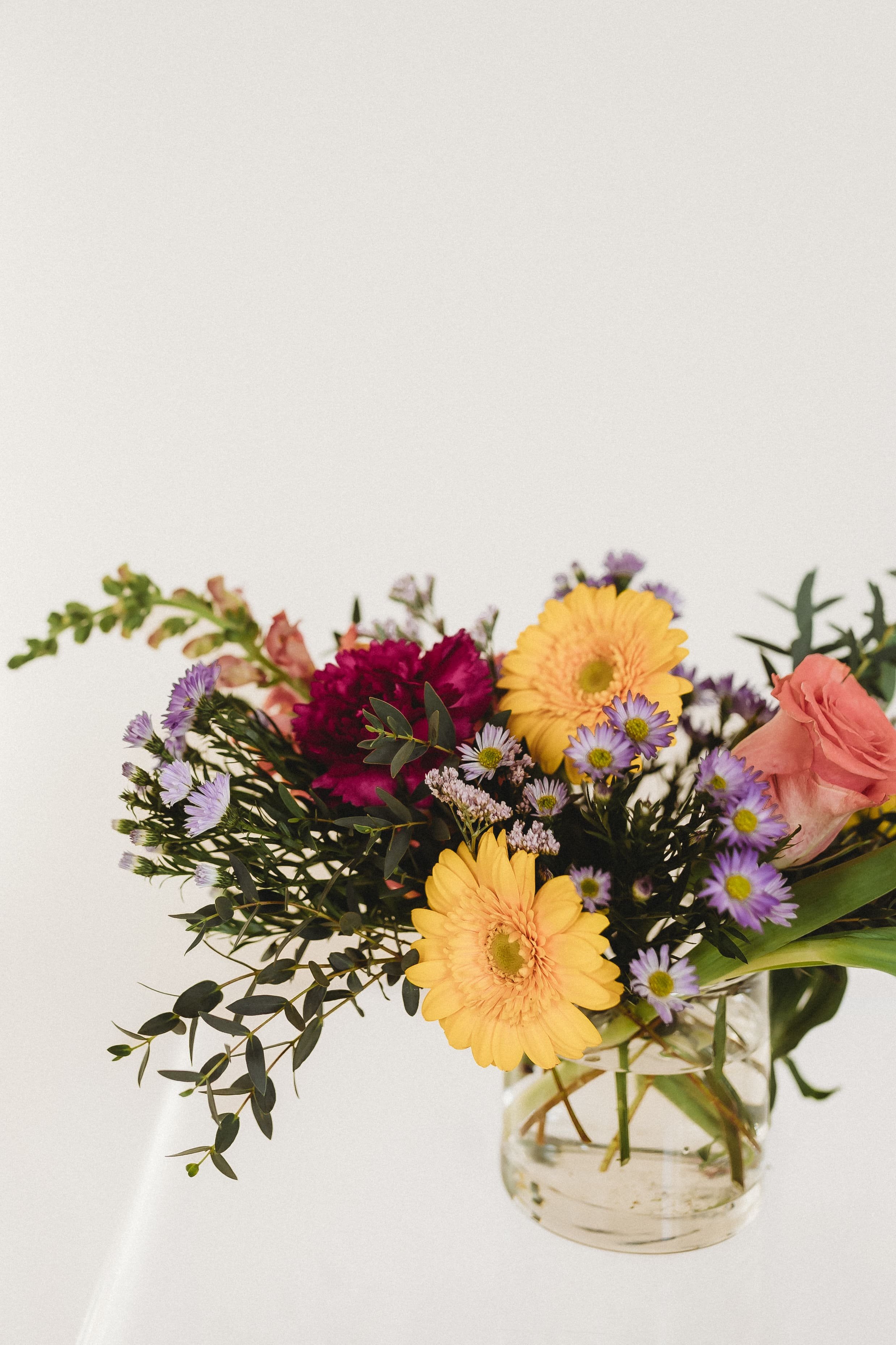  a colorful bouquet of flowers sits on a clear acrylic table 