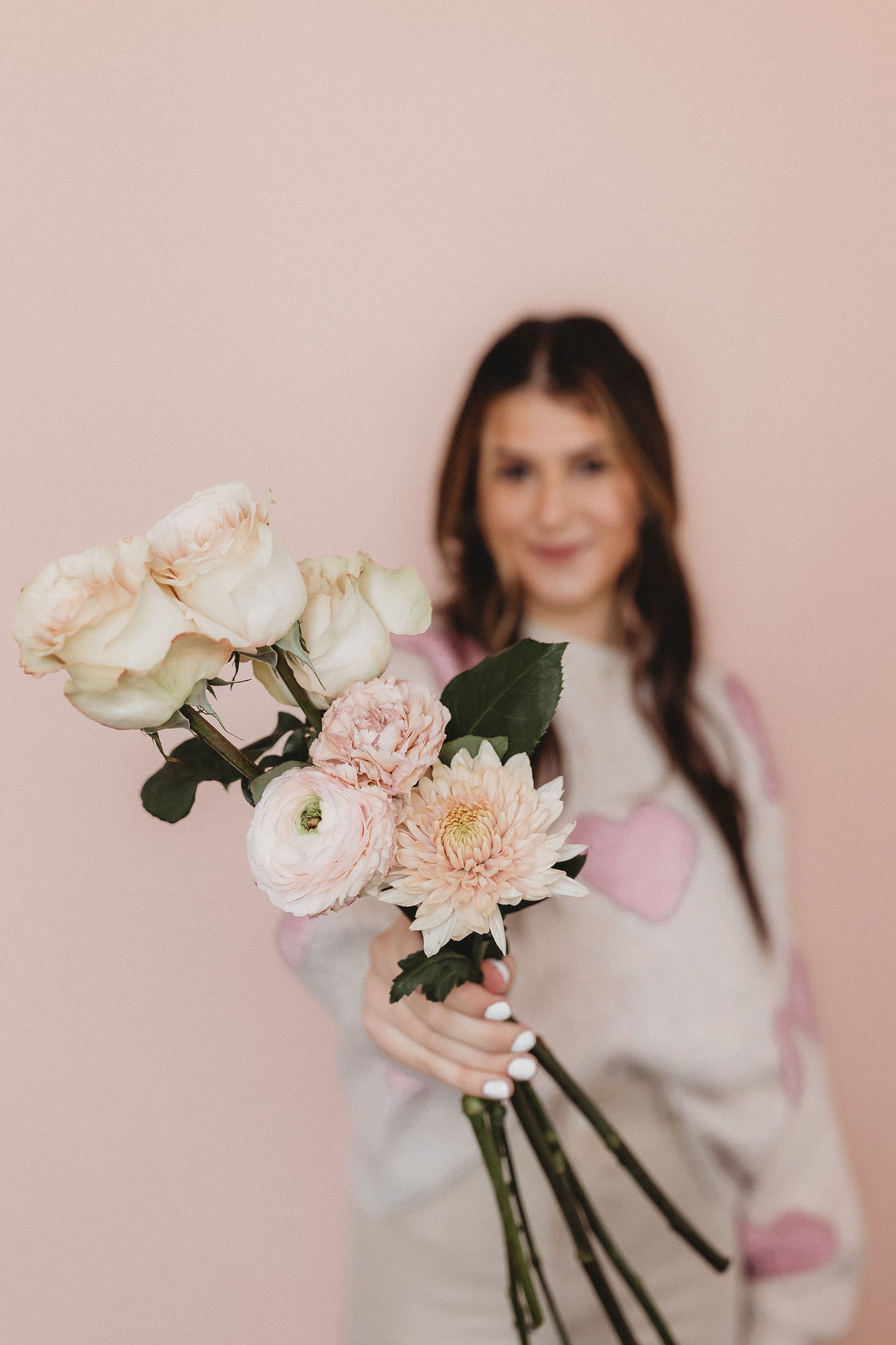  business branding photography a woman holds out a bouquet of flowers 