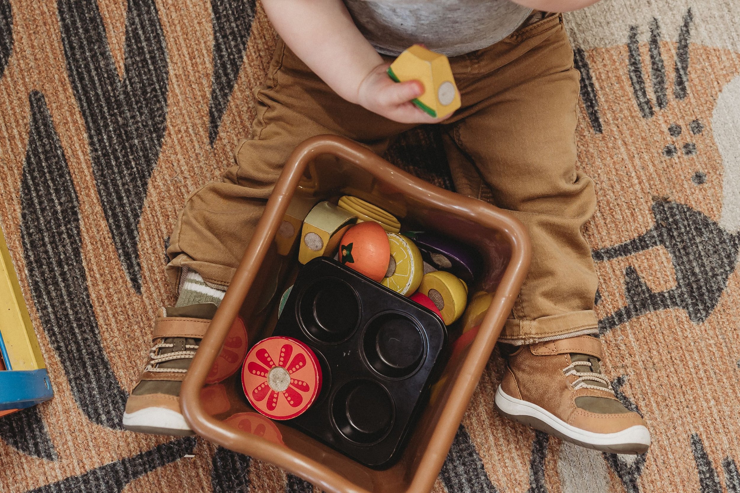  a central illinois photographer captured a toddler’s legs as he plays with a bin of toys 
