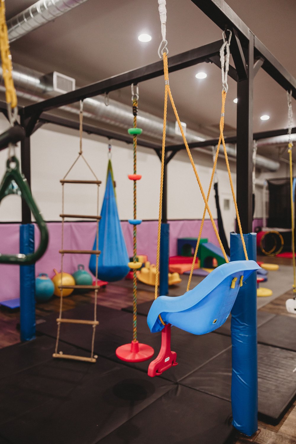  a child’s swing attached to a solid gym structure for a business photography shoott 